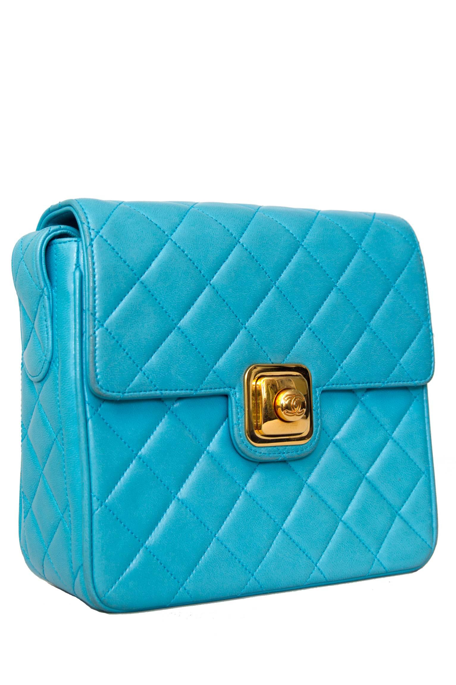 A boxy 90s bright turquoise quilted Chanel leather shoulder bag with gold hardware. 
The bag has one large inner compartment with a smaller side pocket with a zipper closure and a small open top pocket on the outer back of the bag. 
In the front,