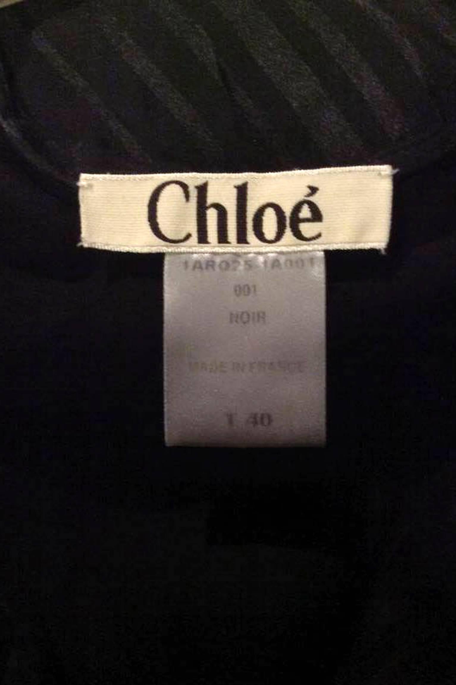 An elegant 80s Chloé black silk chiffon diagonal cut cocktail dress with an a-line wrap front and raw edged sleeves. The dress has a detachable matching waistbelt with a silk velvet trim. The dress has a side zipper and push button closure and is