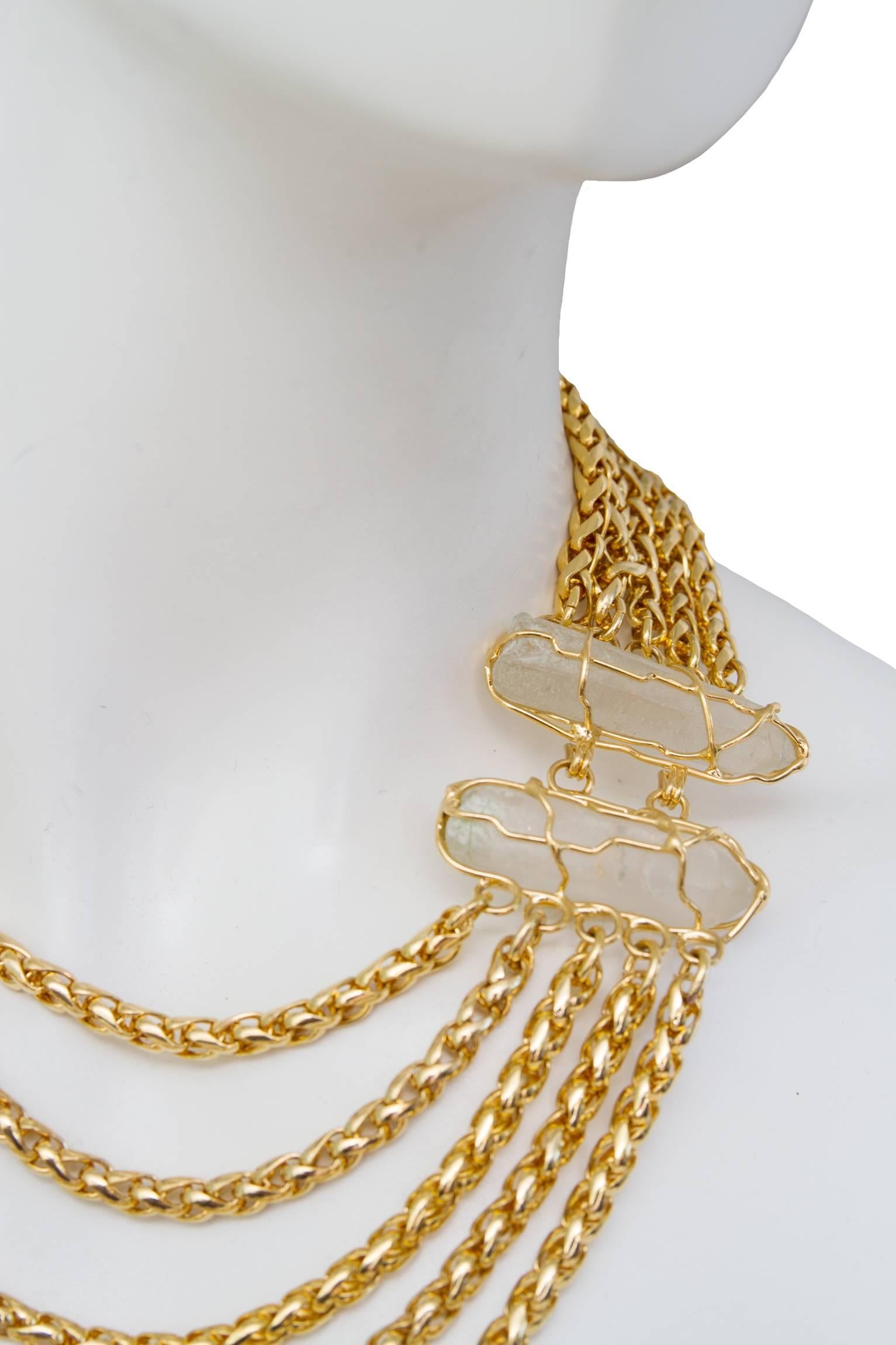 A stunning 1980s Yves Saint Laurent gold-toned chain necklace consisting of five individual strands in varying length. The Strands are attached at the back with a large clear-white raw crystal. The bullet shaped stone is encased in gold and extends