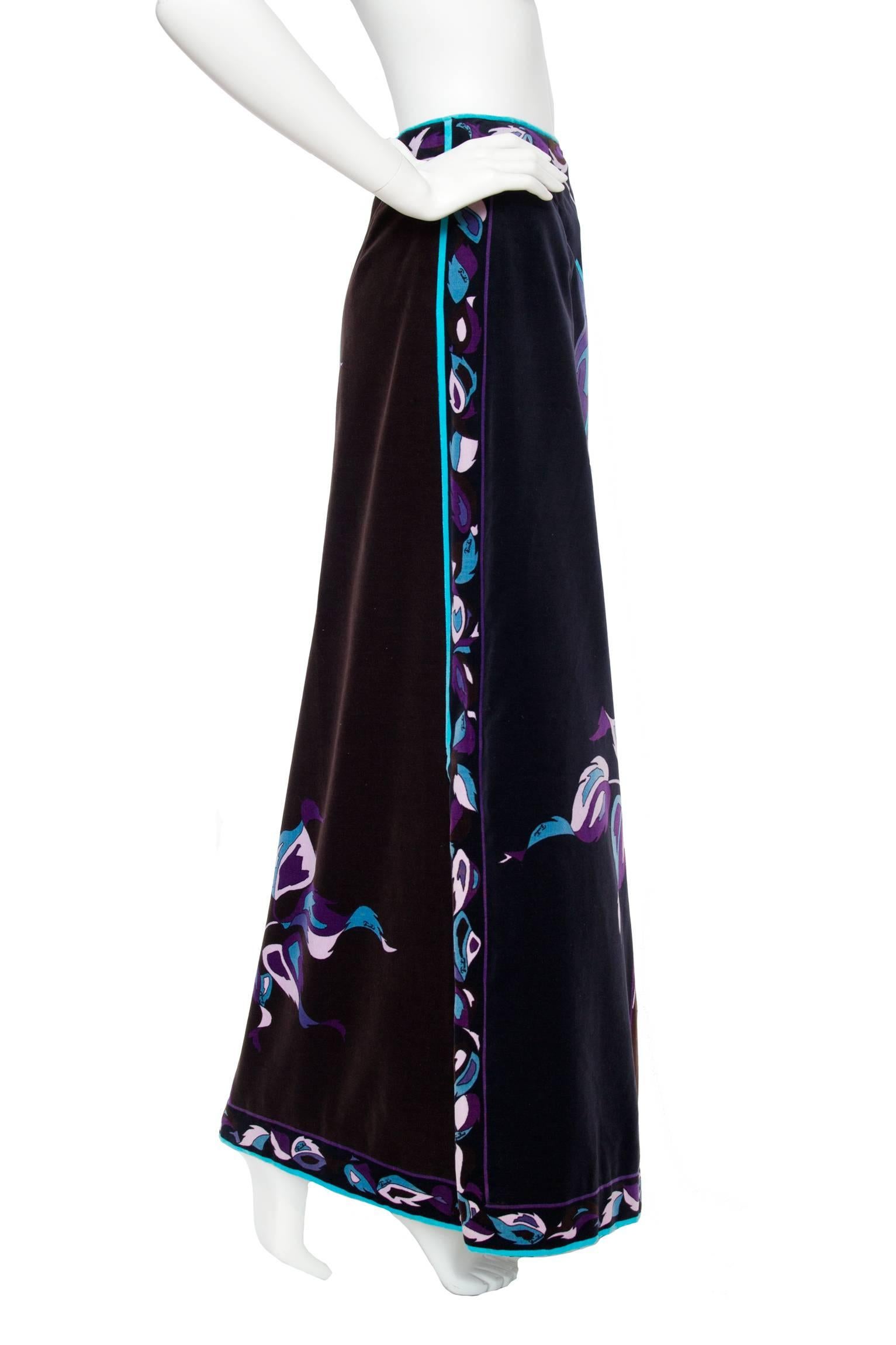 A great 1970s Emilio Pucci floor-length velvet skirt with a characteristic abstract floral print. The print is held in complimenting hues of blue and purple which sets beautifully on a black and brown background. The skirt is fully lined and can be