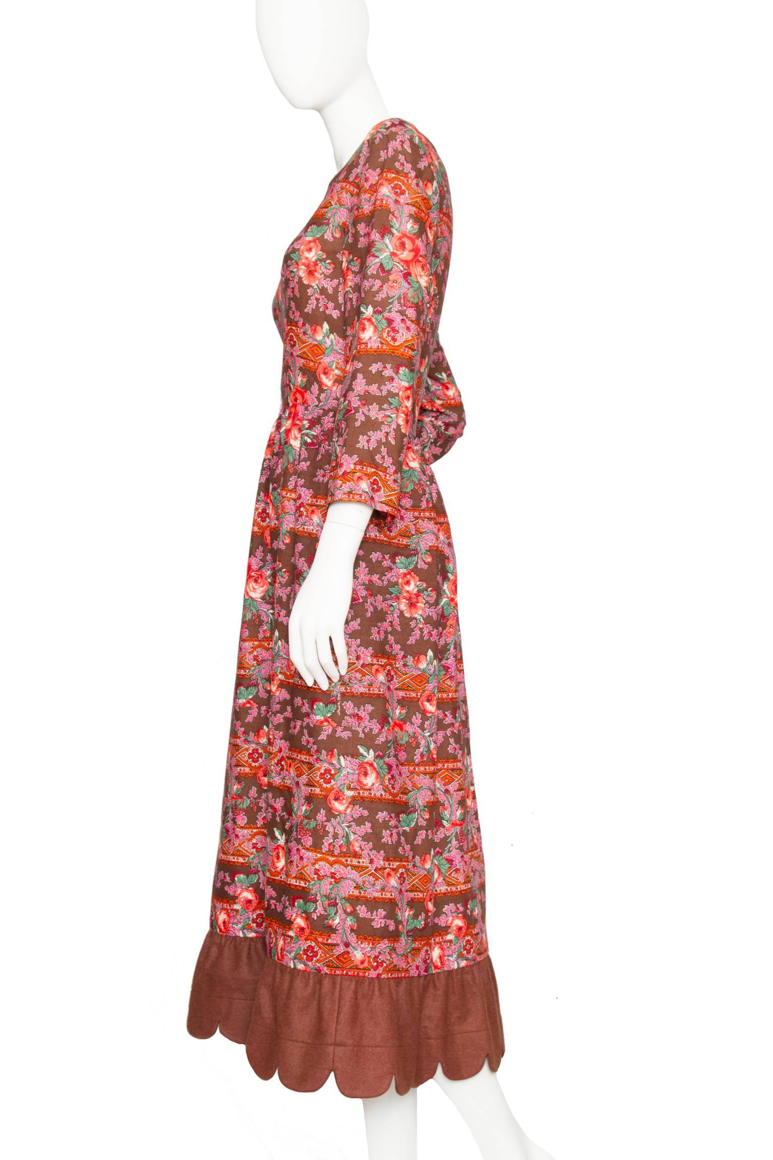 A 1970s Lanvin ankle-length wool dress with a fitted hem, long tapered sleeves, and a round neckline. The dress features a stunning floral print in matching pink hues with accented leaves in green and white, which beautifully compliments the brown