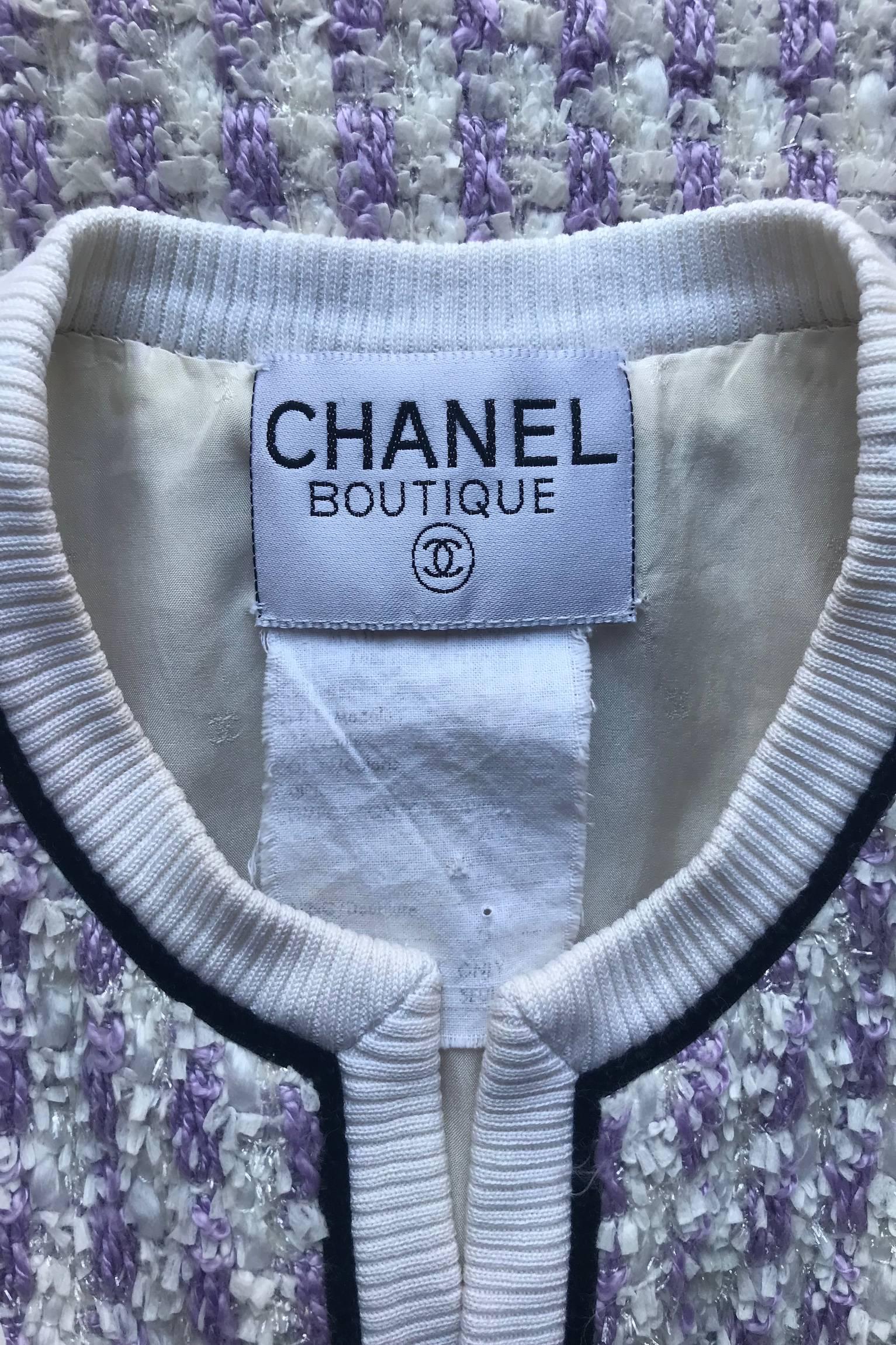 A fabulous white and light purple Chanel boucle skirt suit consisting of a fitted open front jacket and fitted knee-length pencil skirt. The jacket has fitted sleeves, a round collarless neck, a patch pocket situated on both sides of the hip and a