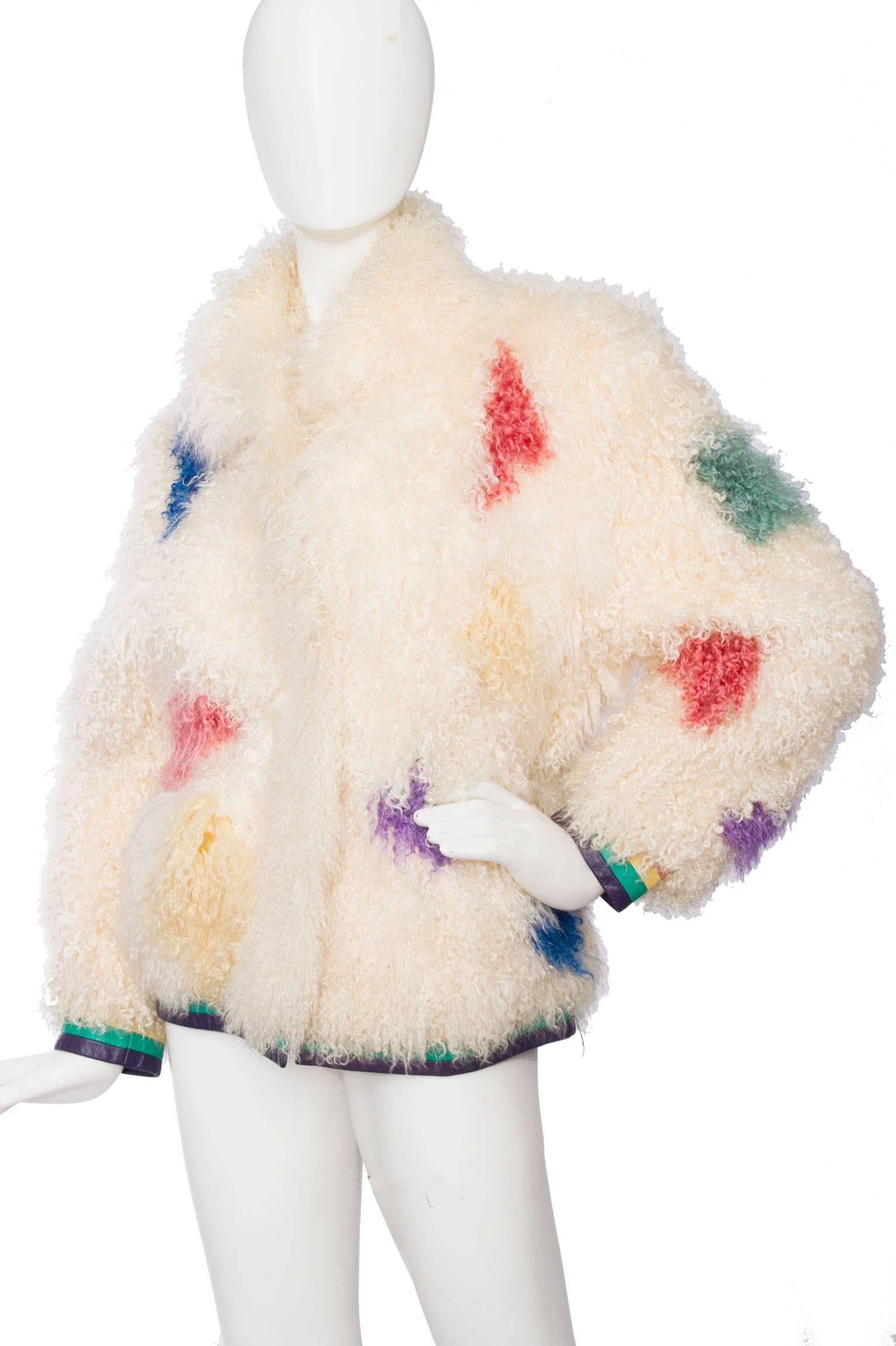 A gorgeous 1980s curly white mongolian lamb fur coat with brightly colored paint splash details in pink, purple yellow and green in various places on the jacket. The coat has a front button closure, is fully lined and has a bright purple, green and