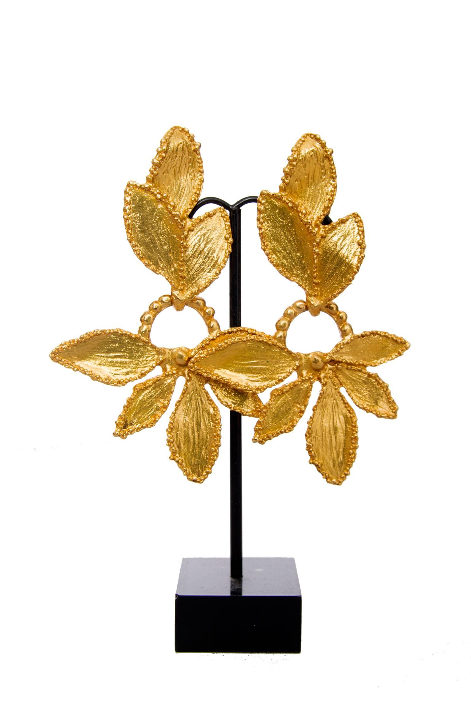 A lovely pair of 1980s Yves Saint Laurent gold plated leaf shaped clip on earrings with a dangling leaf setting hanging from a delicate strand of gold plated beads.

On the back the earrings are stamped: YSL Made in France