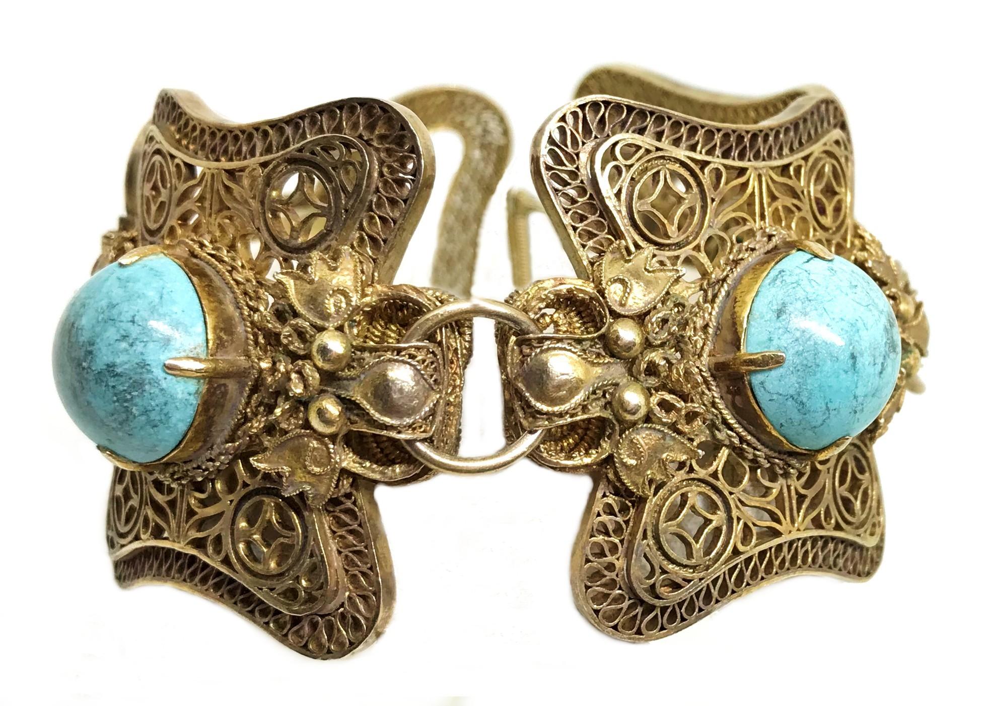 Circa 1960 Chinese gold-plated sterling silver ornate filigree link bracelet, prong set with round turquoise cabochons and embellished with dragon heads between each link.   Safety chain attached.  The condition is very good with minimal wear. 