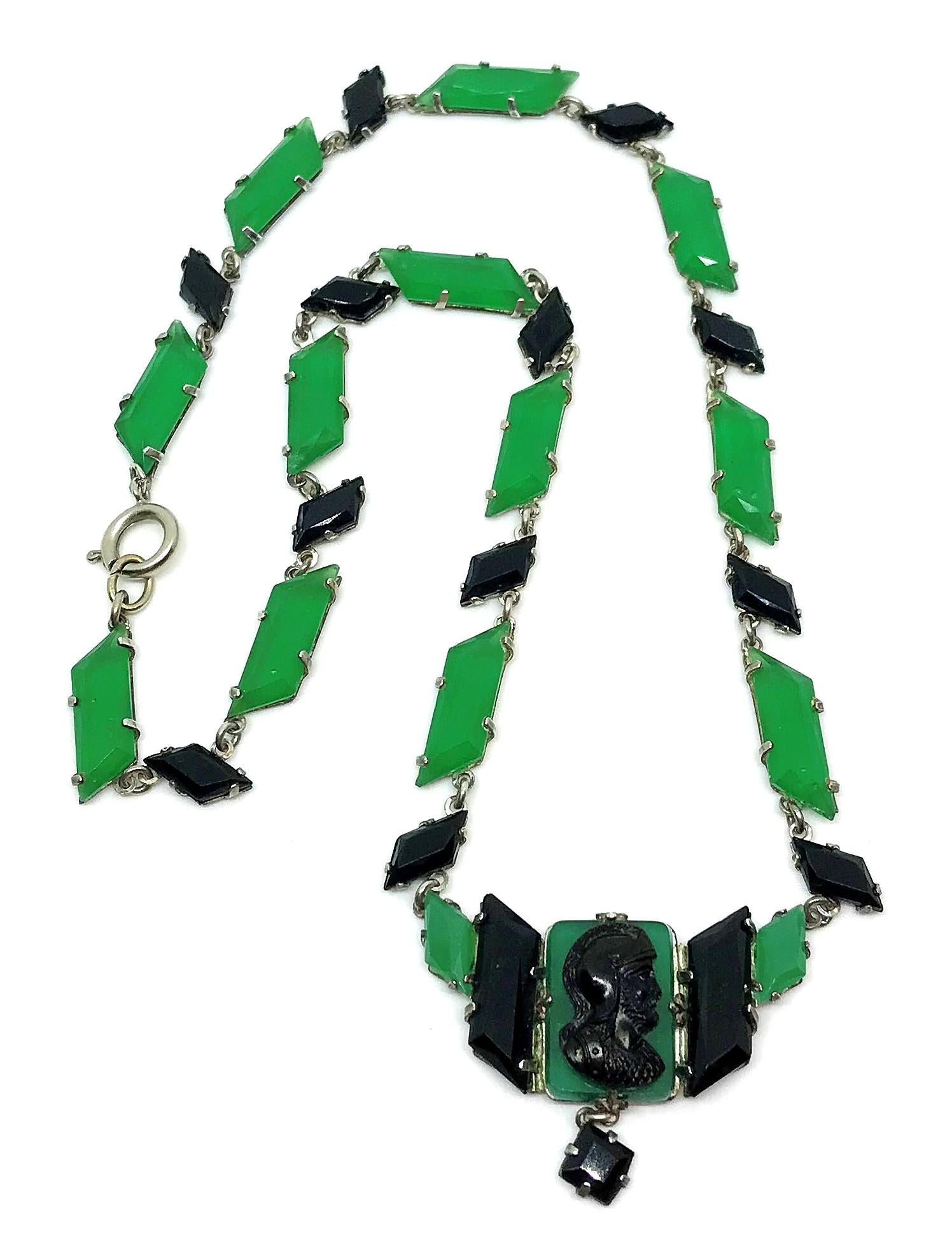 Circa 1920's silver tone metal link necklace prong set with green and black faceted glass stones with a center pendant embellished with a molded black glass Roman Soldier cameo and a small prong set square black glass drop.  It is in extremely good