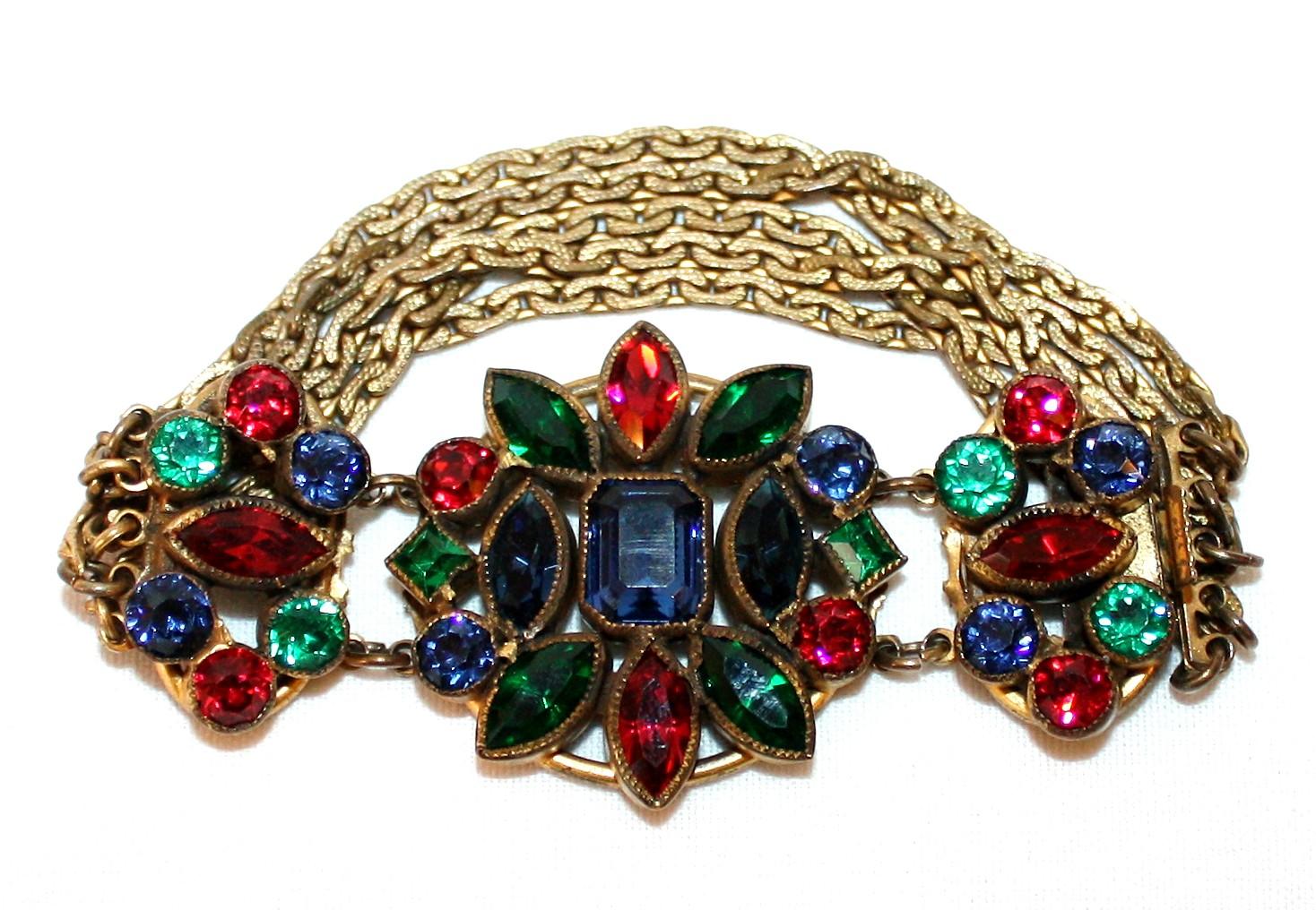 Circa 1930s Czech brass and gold tone metal multi chain bracelet.  The top is bezel set with multi-shaped and faceted jewel tone Bohemian glass stones.  The side closure is firm and secure and the condition is very good with minimal wear.  Unmarked.