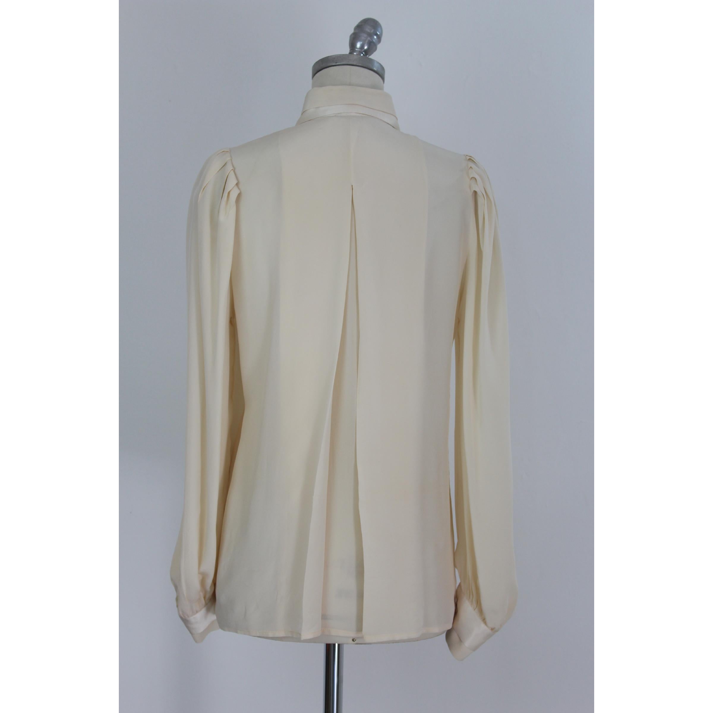 Vintage Pancaldi women's shirt, beige, 100% silk. Hidden buttons, double collar. Made in Italy. Excellent vintage conditions.

Size 42 IT 8 US 10 UK

Shoulder: 42 cm
Bust / Chest: 57 cm
Sleeves: 62 cm
Length: 74 cm