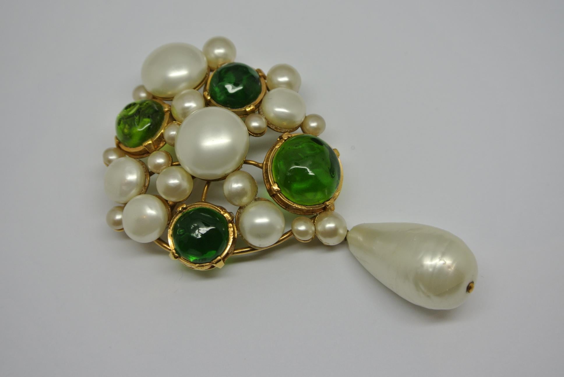 A Chanel signed brooch, dated 1970s. 
comes with green glasses and faux irregular pearls, specially made by Gripoix workshop. Structural shape with large pearl drop. Can be worn as a brooch or a pendant. 