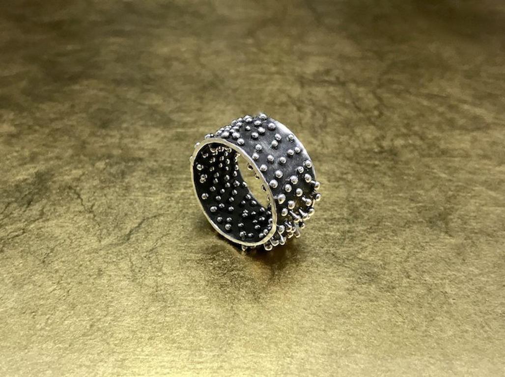 This unique silver band is crafted with 950 sterling silver and features a unique Brutalist design complete with tiny sterling silver movable spikes that provide a unusual comfortable fit. This vintage artisan band would make a great artisan