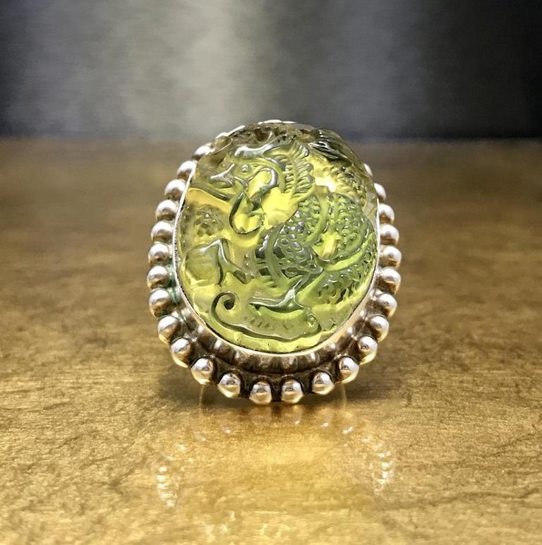 This unique dragon ring is crafted with 925 sterling silver and features a stunning piece of sim transparent greenish/yellowish jadeite jade carved into the shape of an intricate Chinese dragon very 