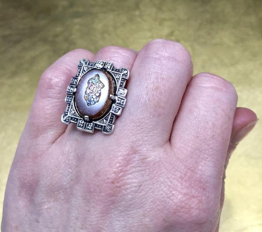 This unique Art Deco ring is crafted with sterling silver in an intricately detailed Art Deco design throughout on both the top and bottom of the ring making it a superbly crafted piece of art deco history. This vintage Art Deco ring features a oval
