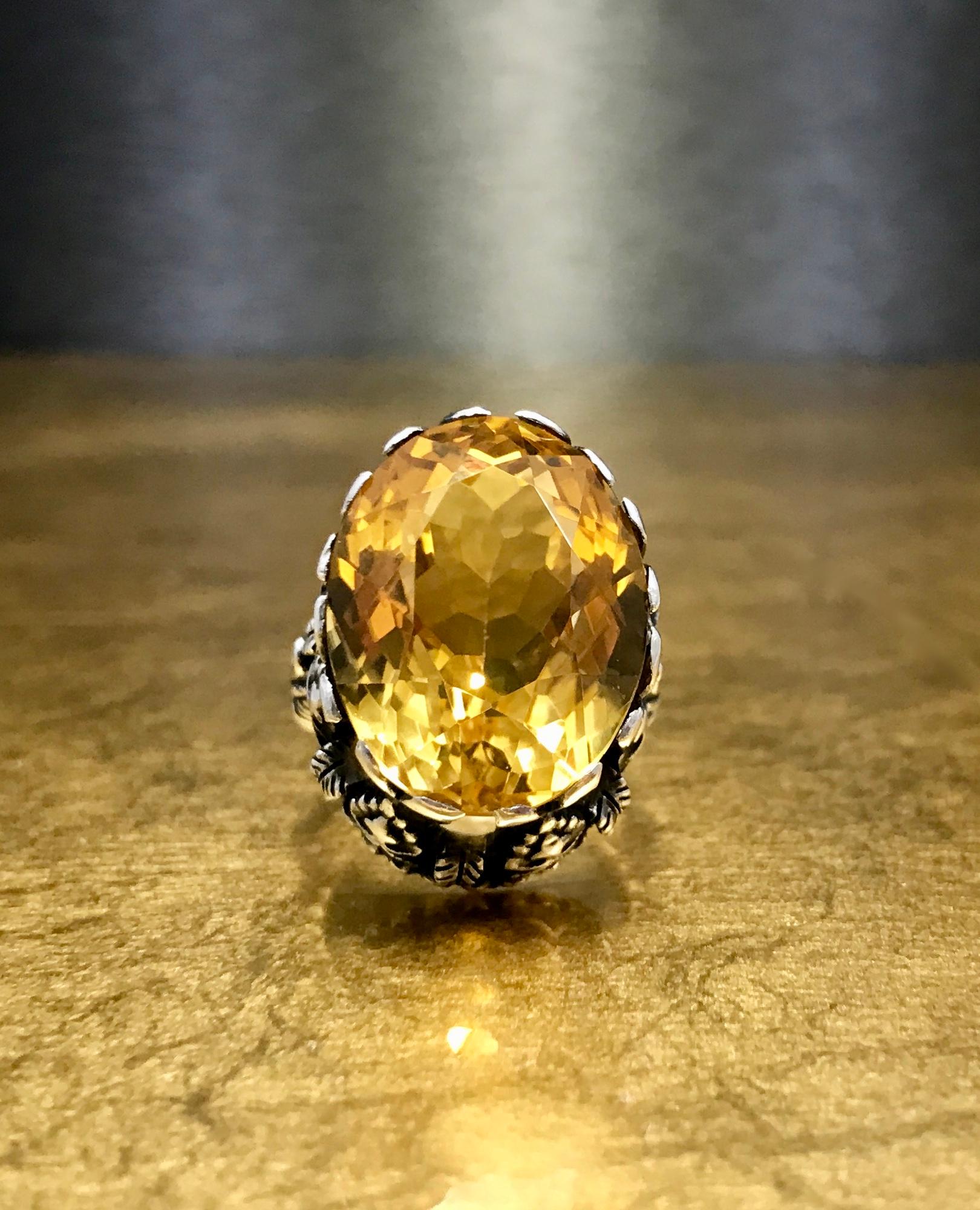 This unique antique ring dates back to the late Arts and Crafts - early Art Nouveau era of the late 1800s. This antique citrine ring is crafted with 925 sterling silver, and features an enormous, oval Portuguese cut, natural citrine gemstone of