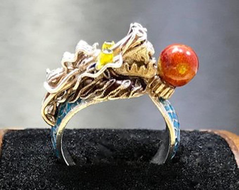 This antique dragon ring is crafted with sterling silver and features an orange nephrite jade stone that is coated in what appears to be an orange enamel. This amazing vintage dragon ring is accented with vibrant yellow enamel eyes, fierce, sterling