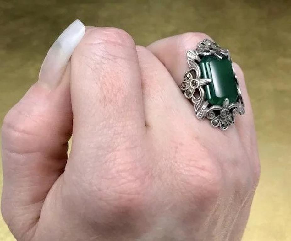 This green vintage ring is crafted with 800 silver and features a mixed emerald cabochon cut green chrysoprase stone, marcasite stones, and unique 1920s Late Art Nouveau - Early Art Deco design. This 1920s Art Deco ring would make a wonderful