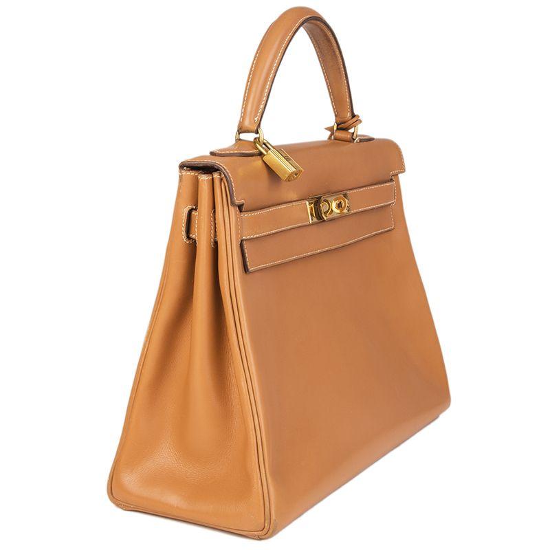 Hermes 'Kelly I 32 Retourner' bag in Naturel (light tan) Veau Box leather with contrasting white stitching. Lined Chevre (goat skin) with two open pockets against the front and a zipper pocket against the back. This bag is vintage 1970. Has been