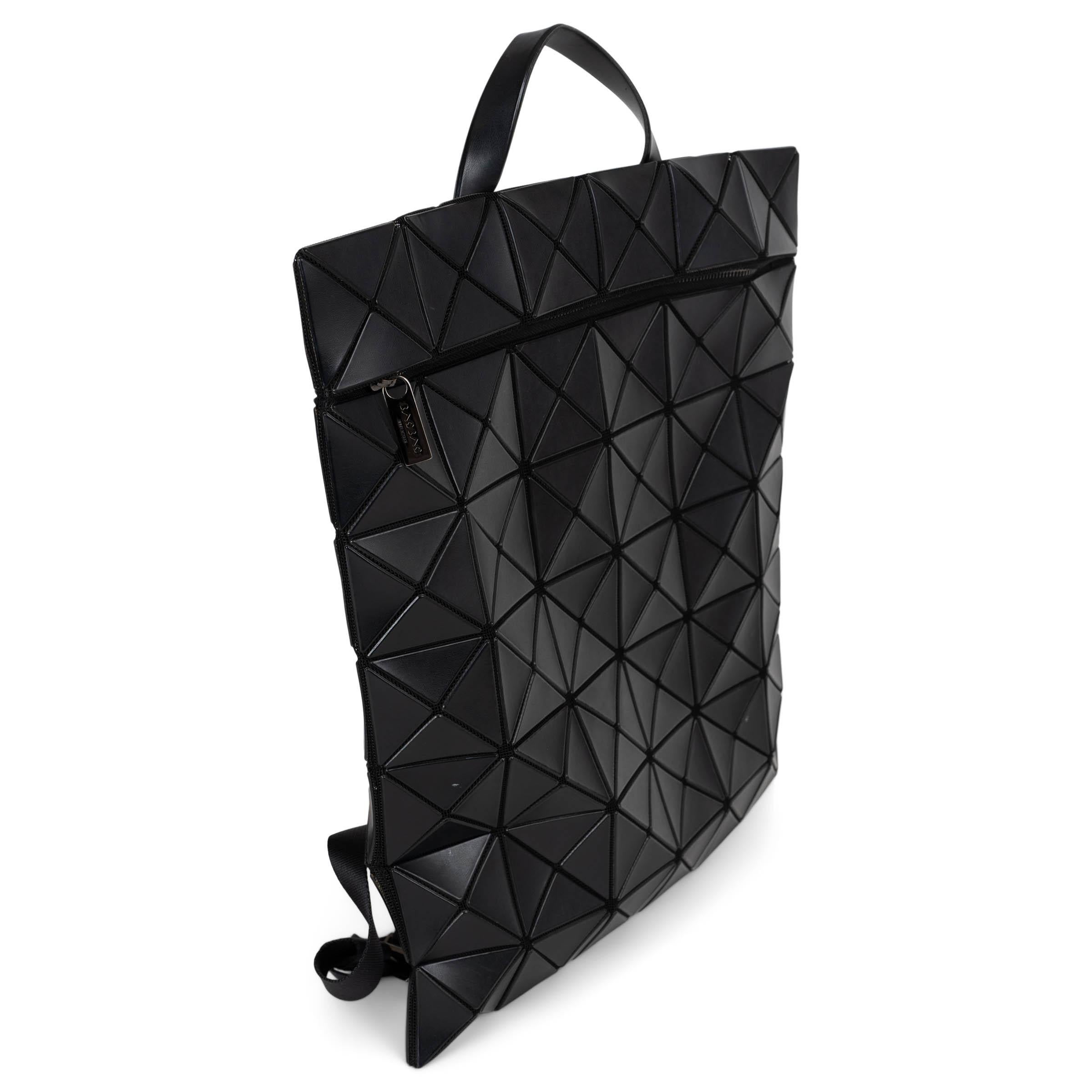 Ce sac à dos Issey Miyake Bao Bao 100% authentique en maille noire est une fusion frappante de design futuriste et de style fonctionnel. Doté de triangles de cuir noir disposés en carrés dynamiques, il crée une silhouette sculpturale et flexible.