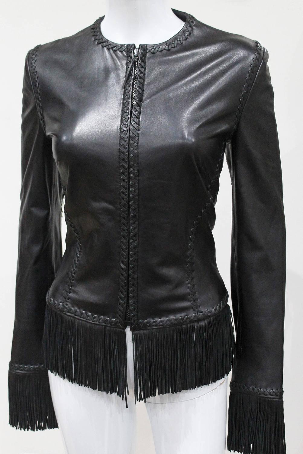 A Gianni Versace black lambskin leather bondage lace up jacket with leather fringing from the Spring/Summer 2002 collection. The seams are highlighted with leather braiding and the cuffs, sleeves and hem are highlighted with 4