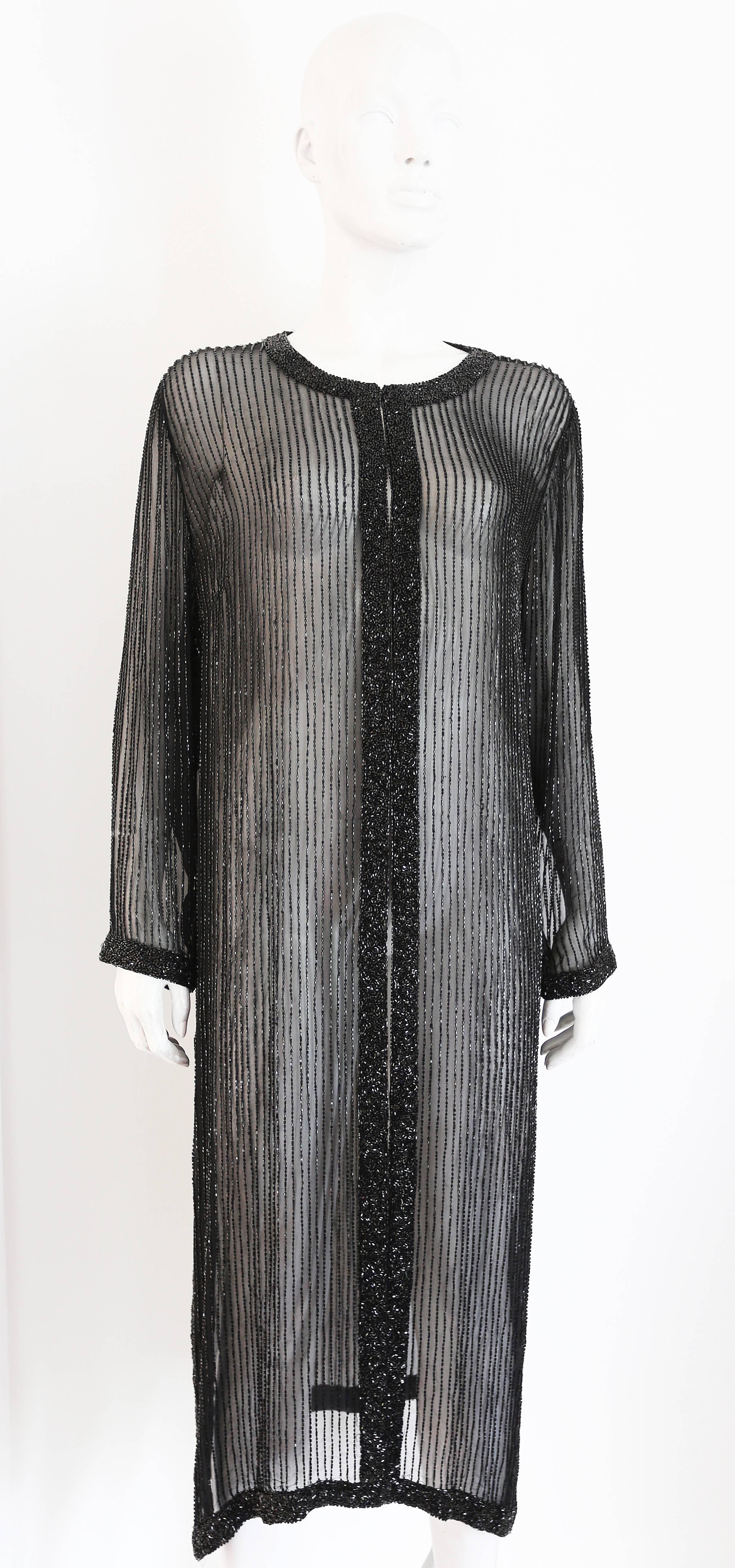 Bergdorf Goodman beaded silk chiffon evening dress coat in a 1920s style, circa  1990s. The coat features hook and eye closure, side slits and thousands of hand sewn decorative beads. 

