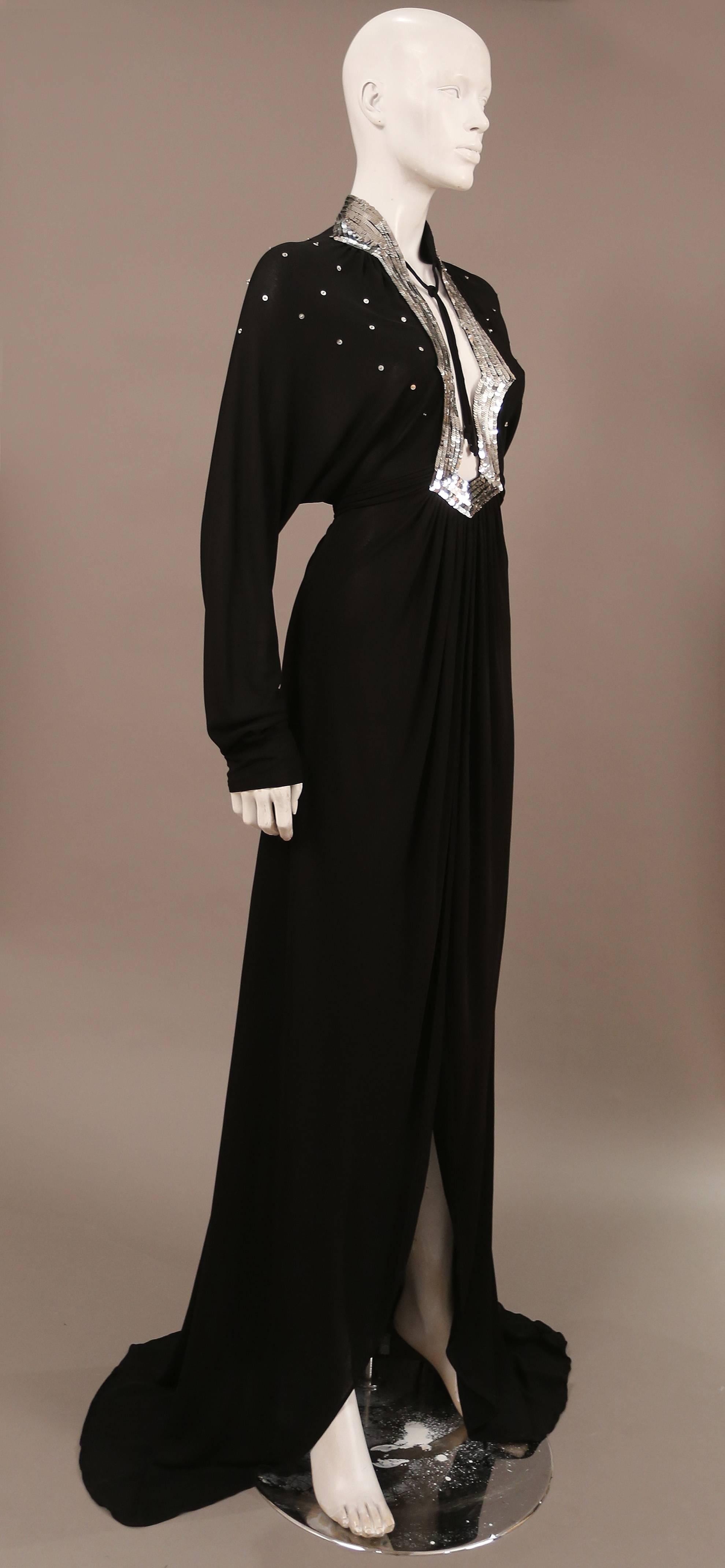 Rare Ossie Clark black jersey evening wrap dress, circa 1978. The dress features sequinned yoke, draped sleeves, low plunge, super high slit and long train at rear. 

Size: uk 10 eu 38
Shoulder to shoulder - 17