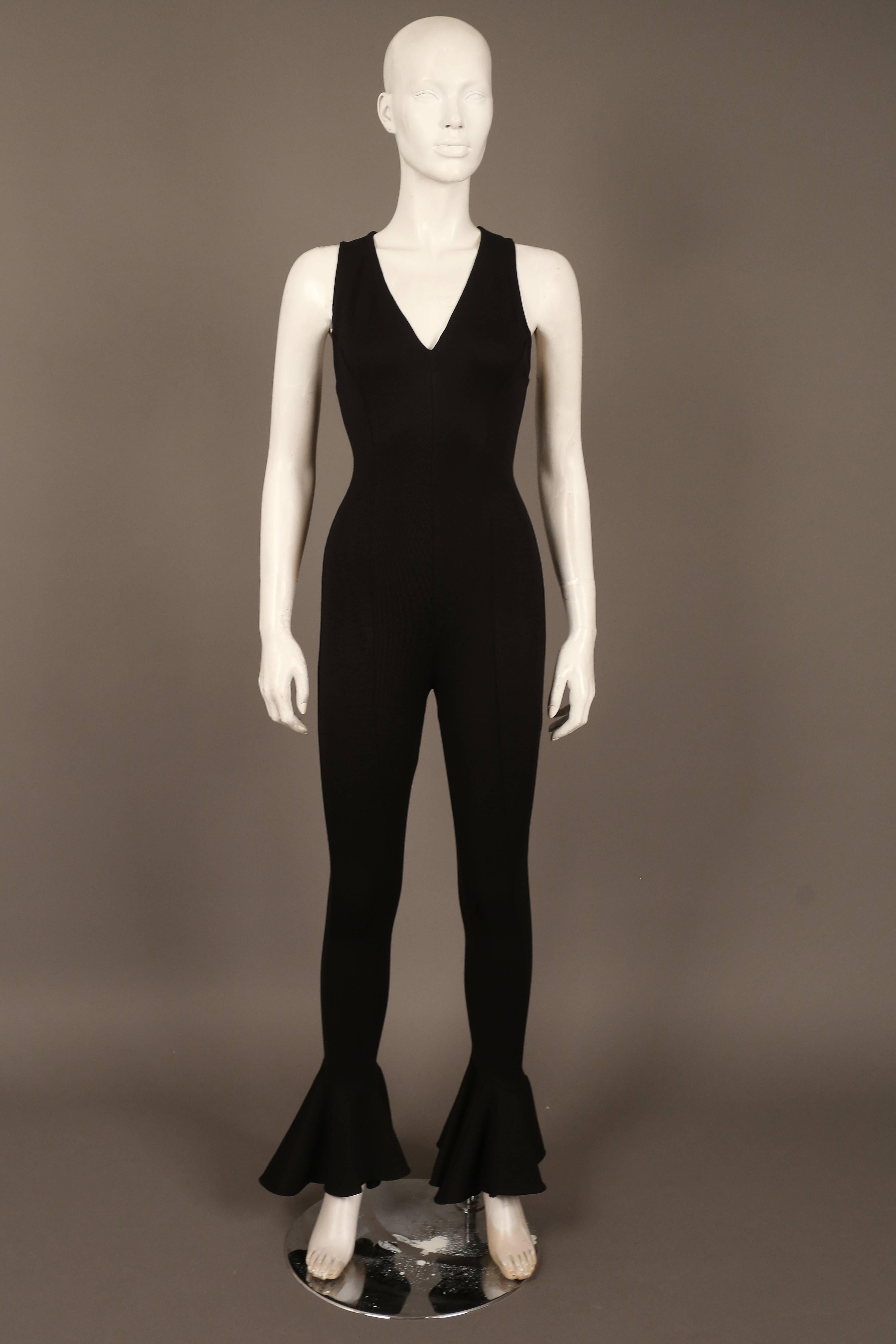 Amazing Gianni Versace black spandex jumpsuit from the 1990s. The jumpsuit features bell bottom pants, super figure hugging spandex, low plunge and invisible zipper at rear. 

IT 40  EU 36  UK 8 