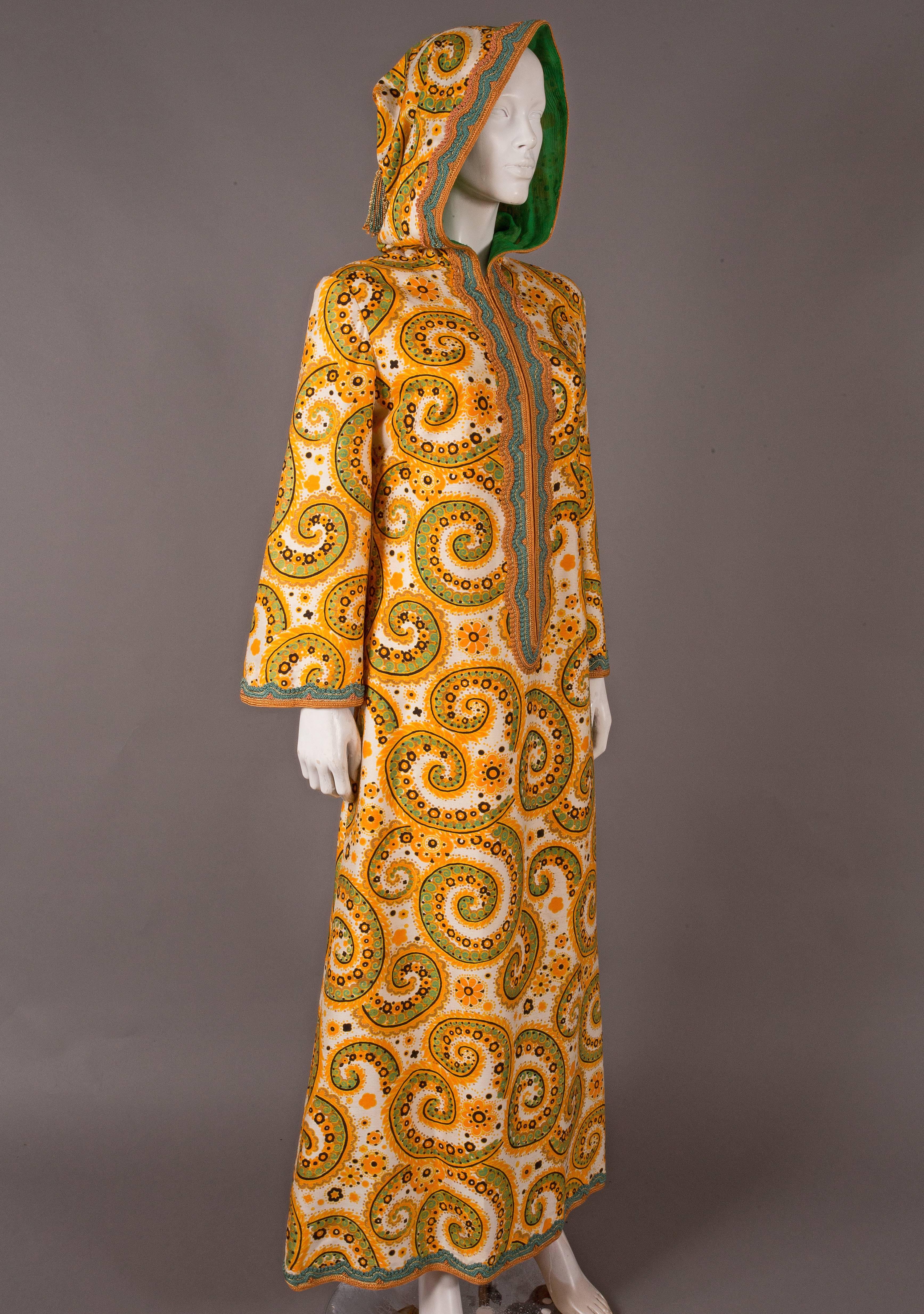 Rare Thea Porter Couture hooded raw silk caftan, circa 1970s. The caftan features hand embroidery throughout, silk chiffon lining in hood, tasseled hood and zip closure. 

Medium