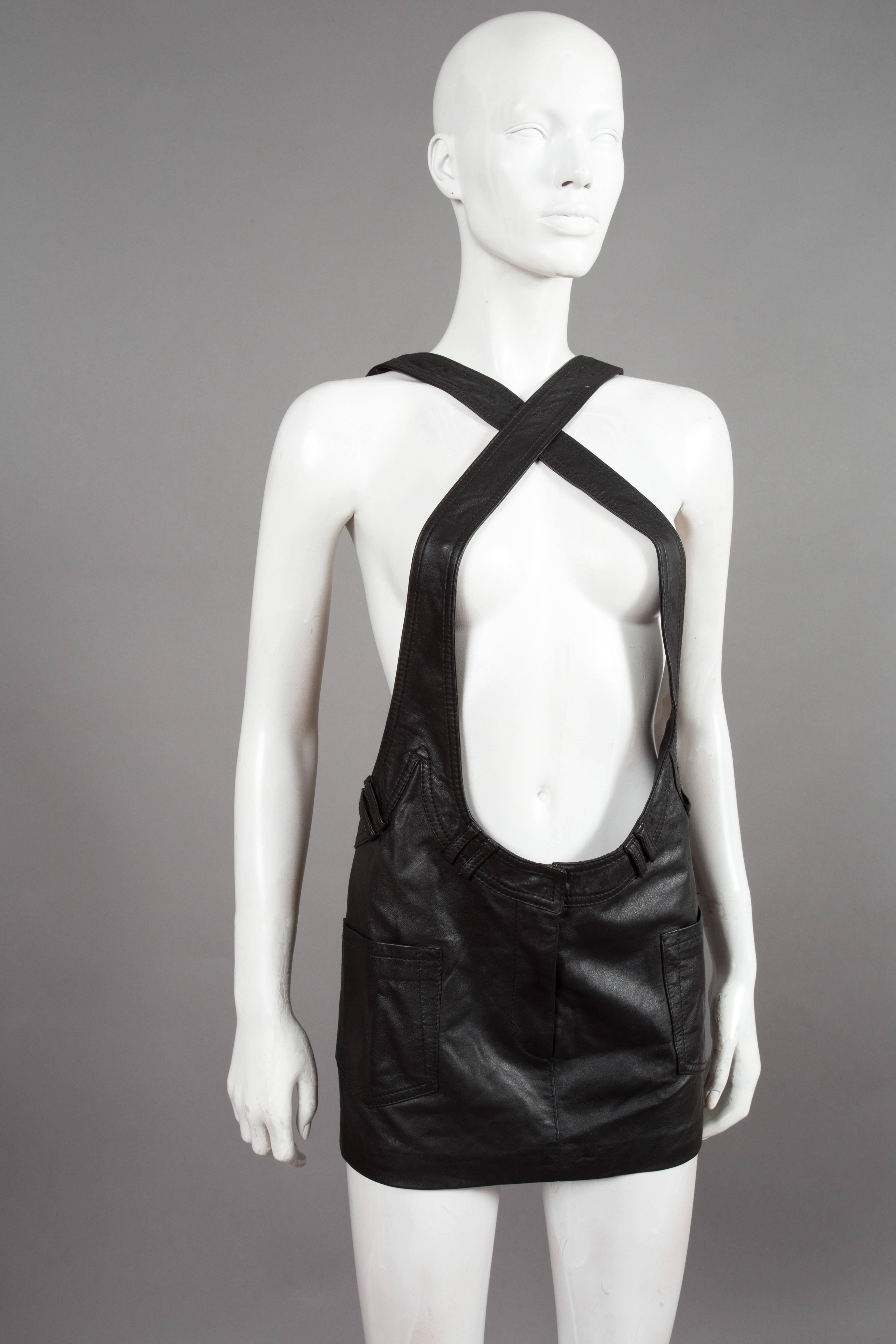 Alexander Wang black leather pinafore mini dress, spring/summer 2010 collection. The dress features adjustable cross-over shoulder straps with large snap button closures, two front open pockets, zip fly and 100% silk lining.

US 2  EU 34  UK 6  XS