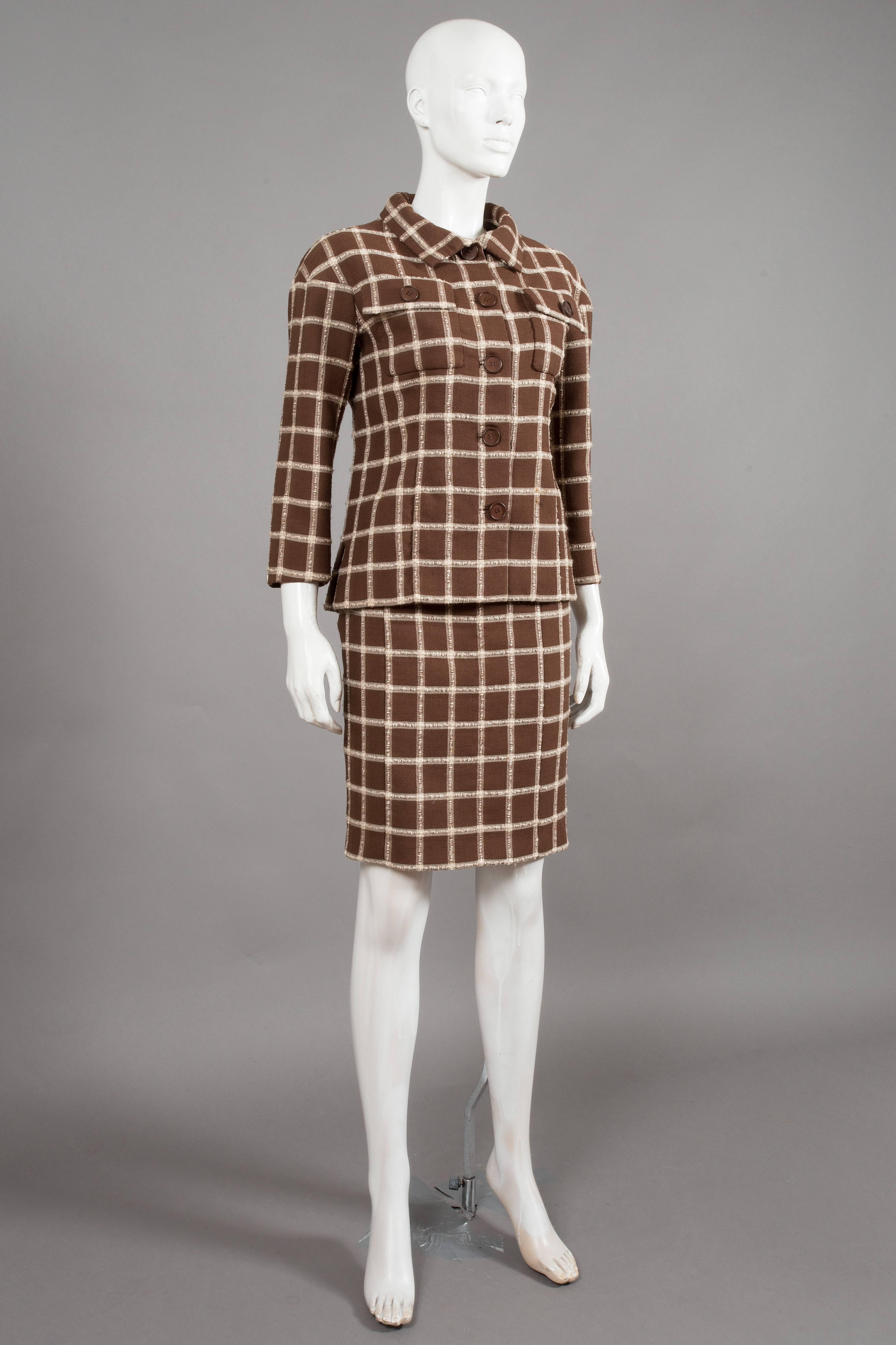 A Balenciaga couture flecked brown and cream checked tweed suit, circa 1965, EISA labelled, tailored jacket with side slits, brown 4 hole flat buttons, two faux pocket flaps on chest and cropped sleeve, over the knee pencil skirt with metal zip