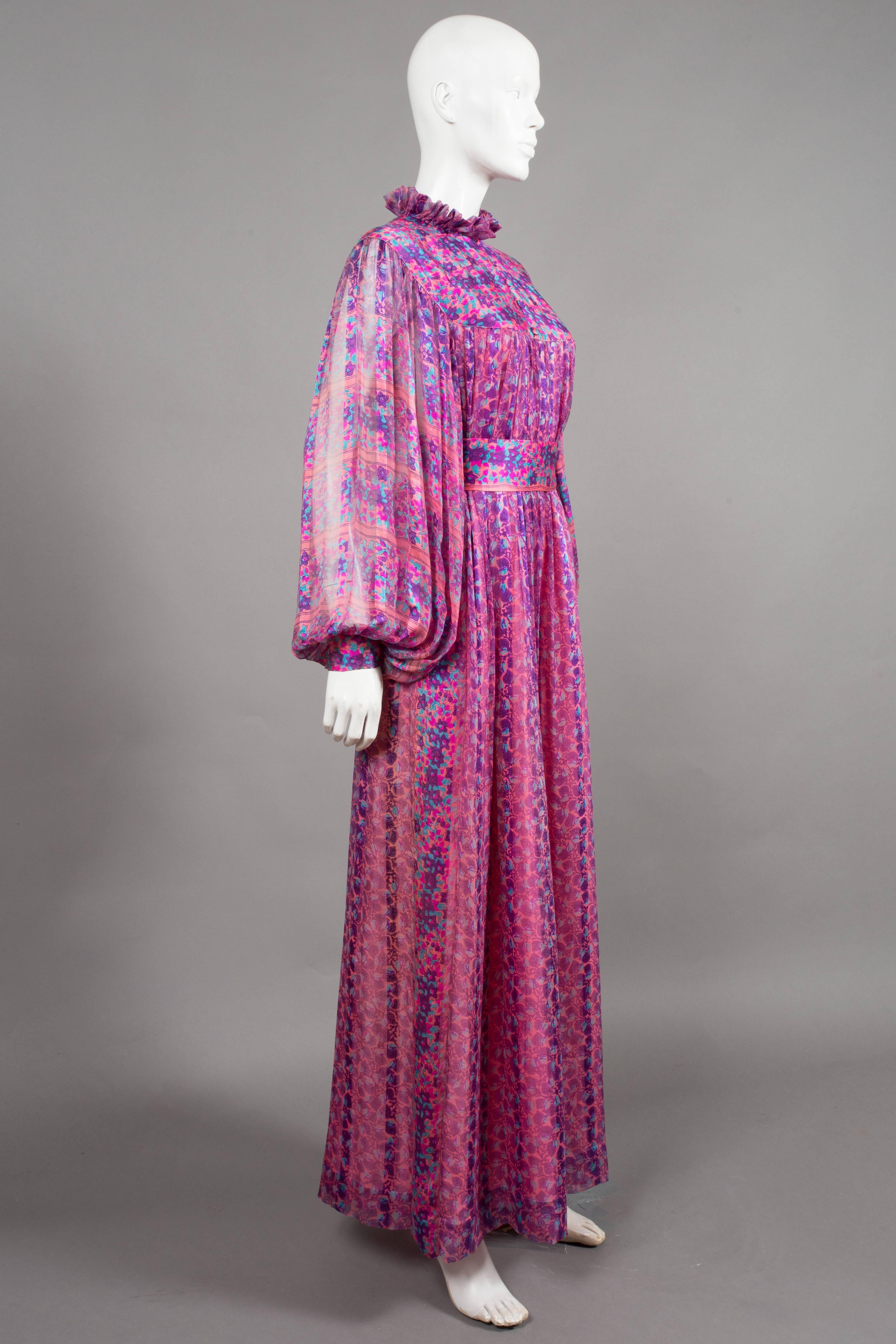 Beautiful and rare Thea Porter silk chiffon evening dress in an abstract floral print. The dress features exaggerated bishop sleeves, silk yoke, ruffled collar, fabric button closures, silk lining and waist belt with ties at rear. 

