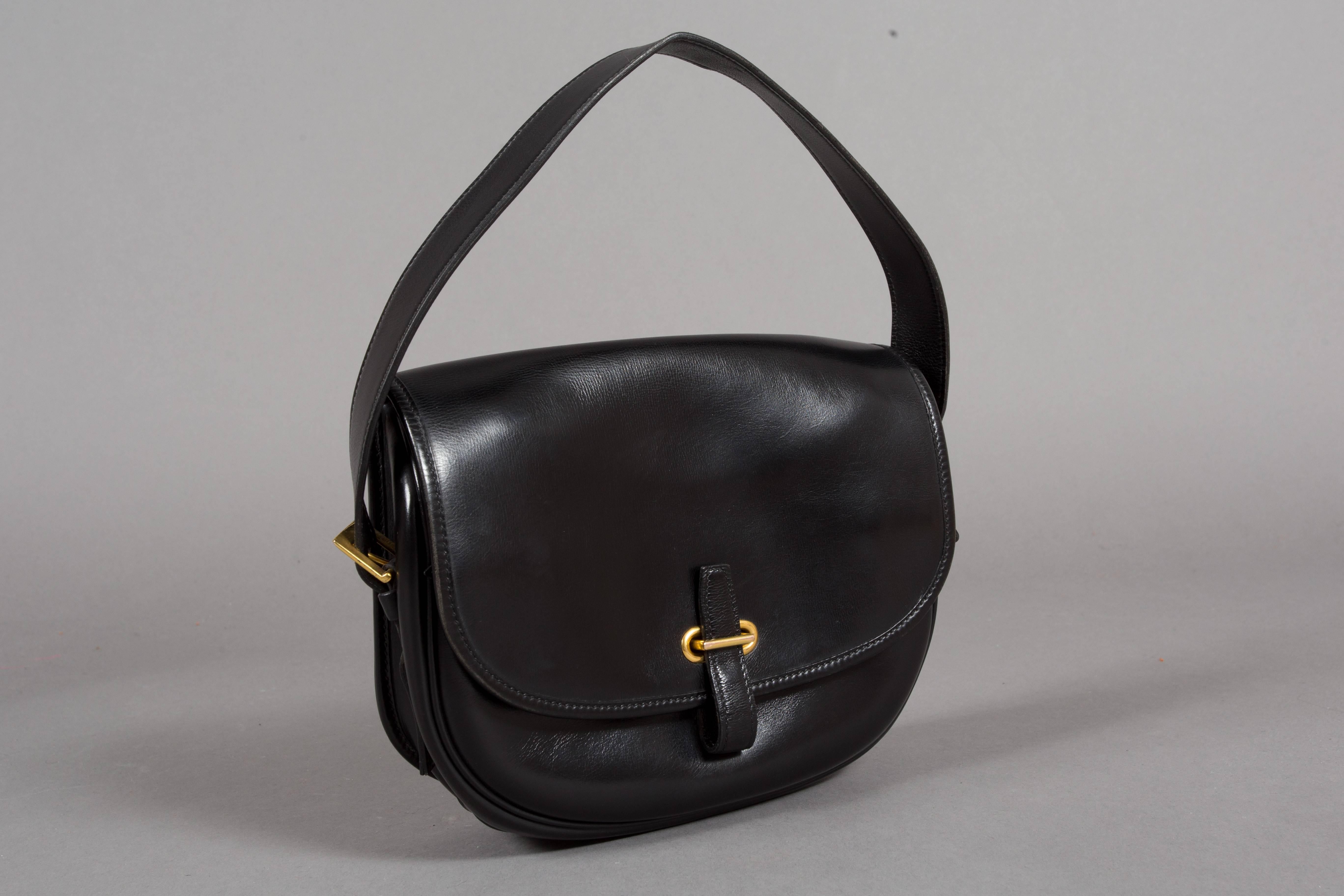 A fine and rare Hermes 'Balle de Golf' bag. Made in France for Bonwit Teller in 1972. The bag is in black box leather with gold hardware, the shoulder strap is adjustable with buckle closure on both sides. One main compartment with an open pocket