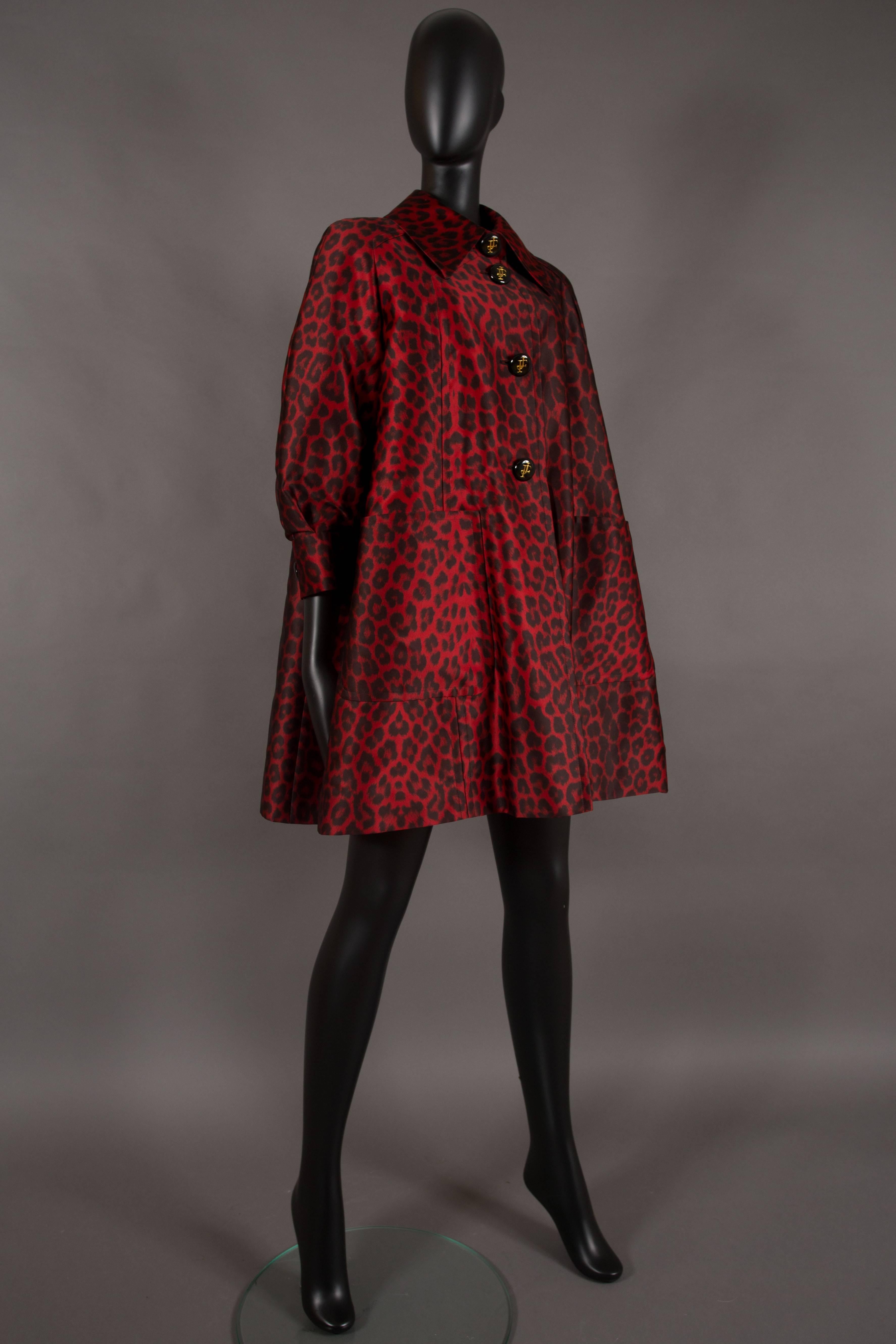 A Jacques Fath evening silk swing coat, autumn winter 1992. Luxurious leopard print silk in red and black, quilted interior, large black enamel buttons with gold 'JF' logo, cropped puff sleeves and swing style design. 