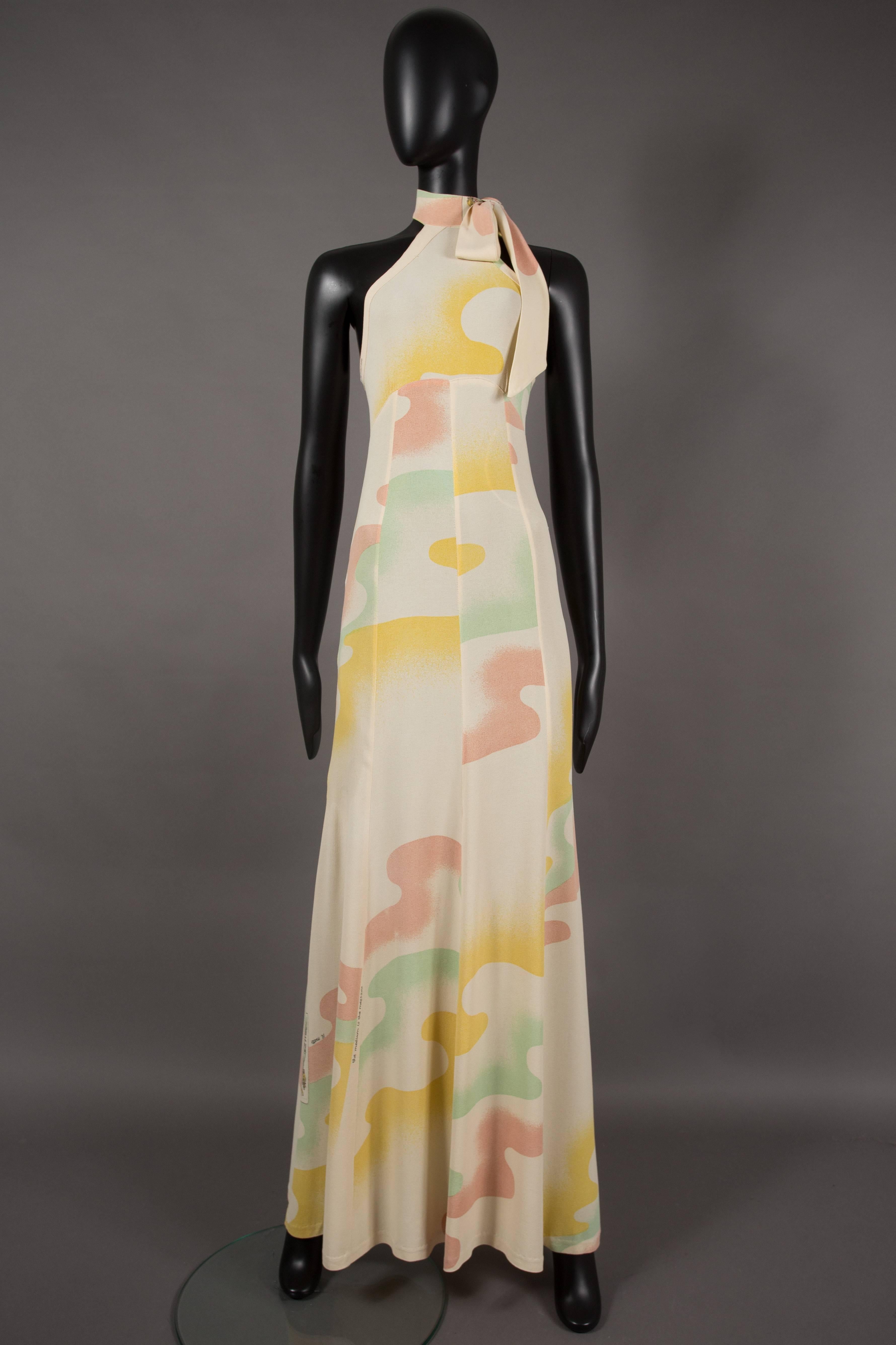 A rare summer evening dress in moss crepe from the Quorum boutique. Halter-neck design with bow fastening, open back with two diagonal straps attached to the collar and 'The medium is the message print' designed by Celia Birtwell.  

Alice Pollock