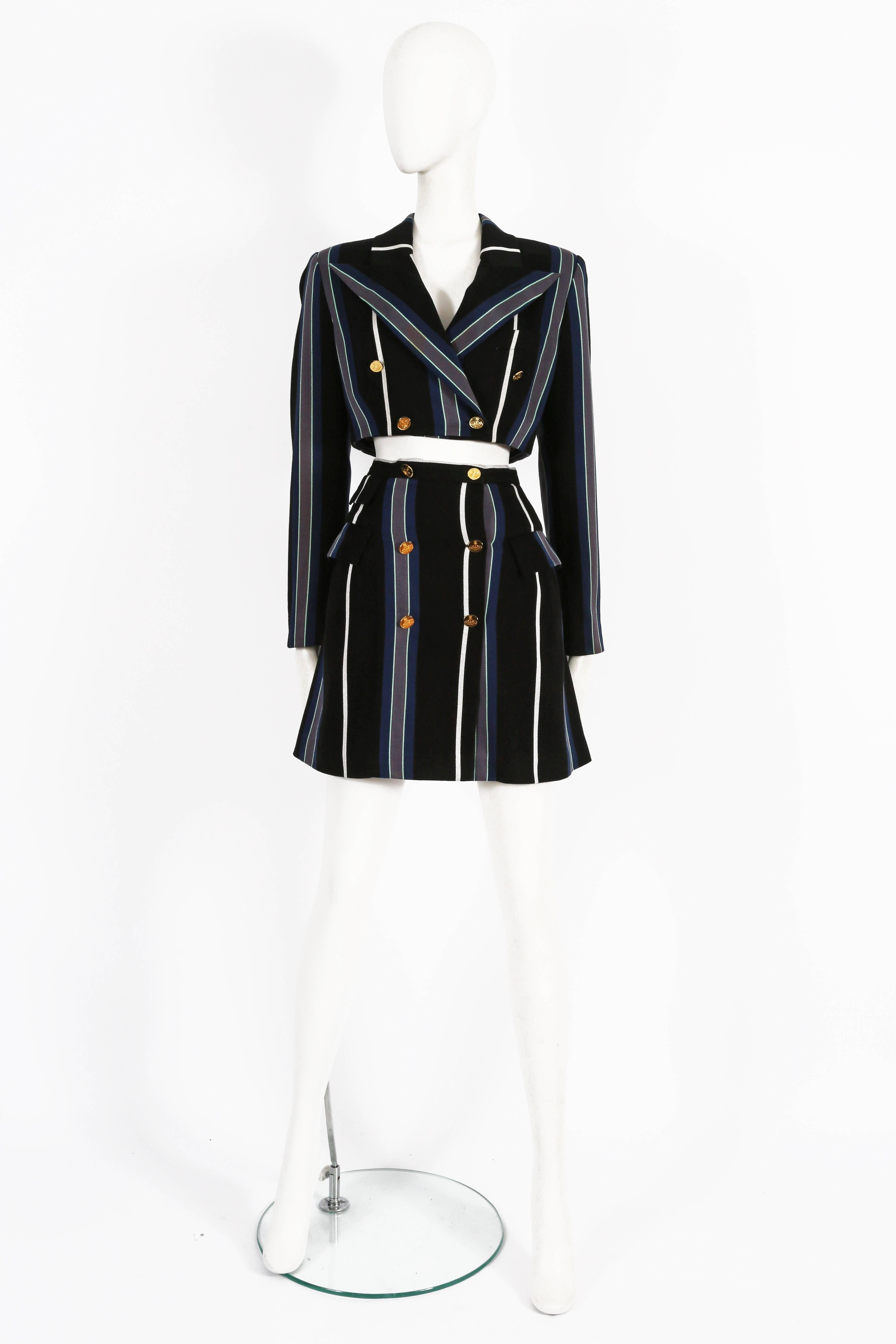 A rare Vivienne Westwood skirt suit, Spring-Summer 1995. The suit is constructed in a striped tweed throughout with satin lining. The jacket is double breasted and closes with gold-tone Westwood orb buttons. The high-waisted skirt has a built boning