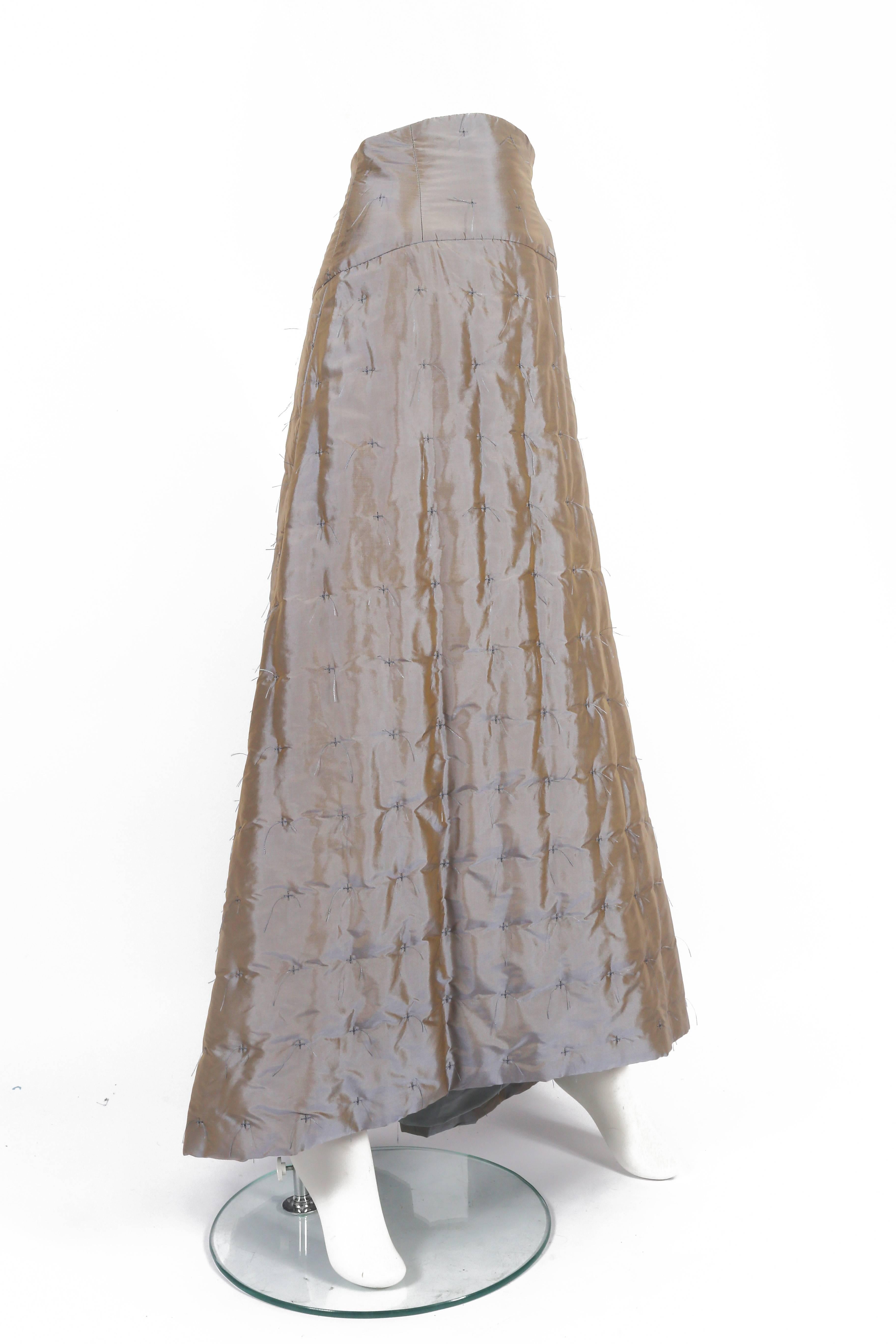 Introducing an enchanting Chanel evening maxi skirt designed by Karl Lagerfeld. This exquisite piece is crafted from iridescent silk taffeta, exuding opulence and sophistication. The quilted allover pattern, adorned with delicate cross-stitches,