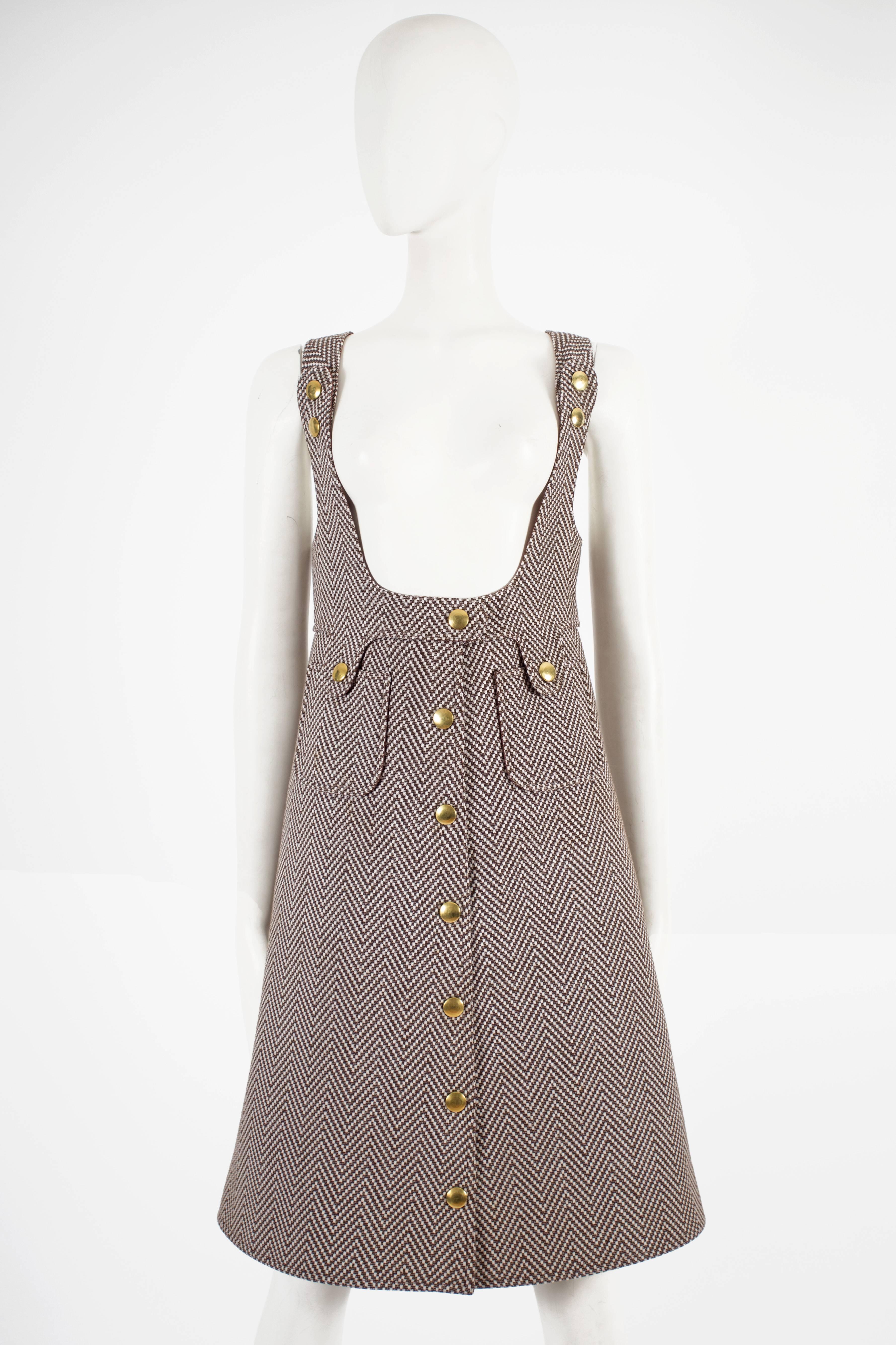 Courreges Haute Couture pinafore dress constructed in brown and ivory tweed, circa 1969. The dress features snap-button closures throughout, gold-tone stud buttons, open back, and brown silk lining.

