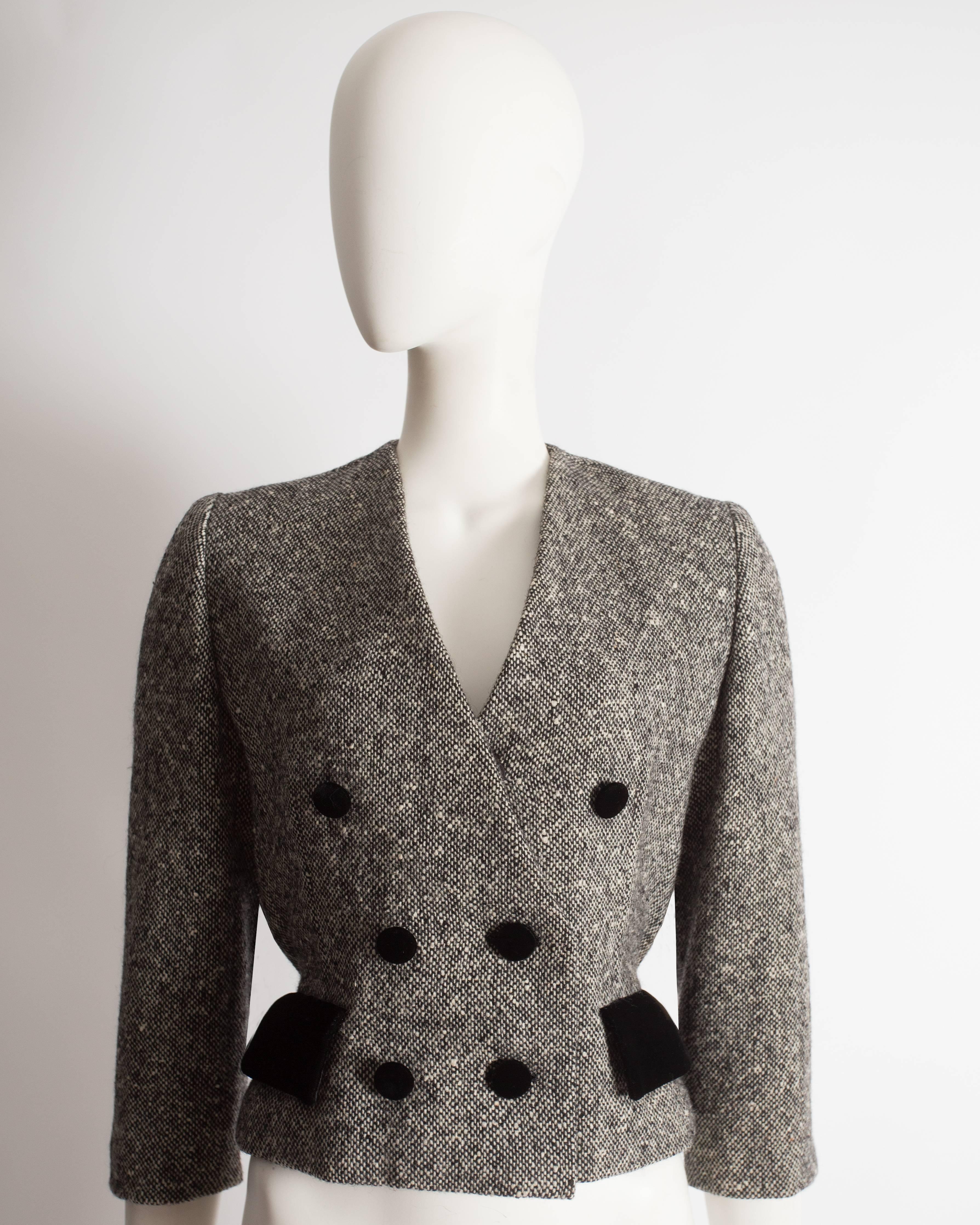 Fine and rare Haute Couture Christian Dior jacket constructed in grey tweed, 100% wool with black silk lining, silk velvet buttons and flap pockets, hidden snap button closures and pleated waistband at the rear. 

Circa 1950

Excellent condition