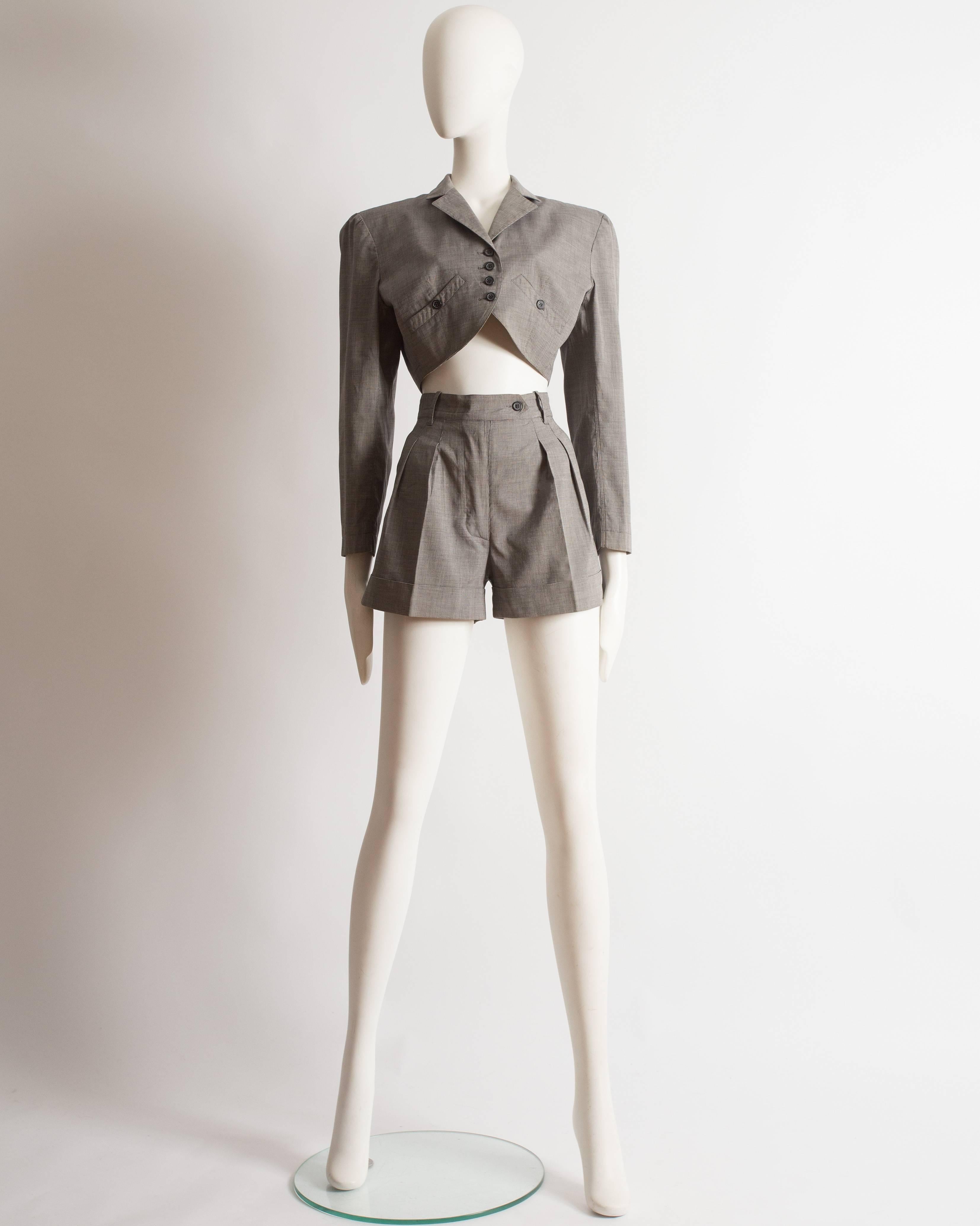 Introducing an iconic Azzedine Alaia suit from the spring-summer 1988 collection. This suit showcases the legendary designer's impeccable tailoring and timeless style.

Constructed in grey cotton, the suit exudes sophistication and versatility. The