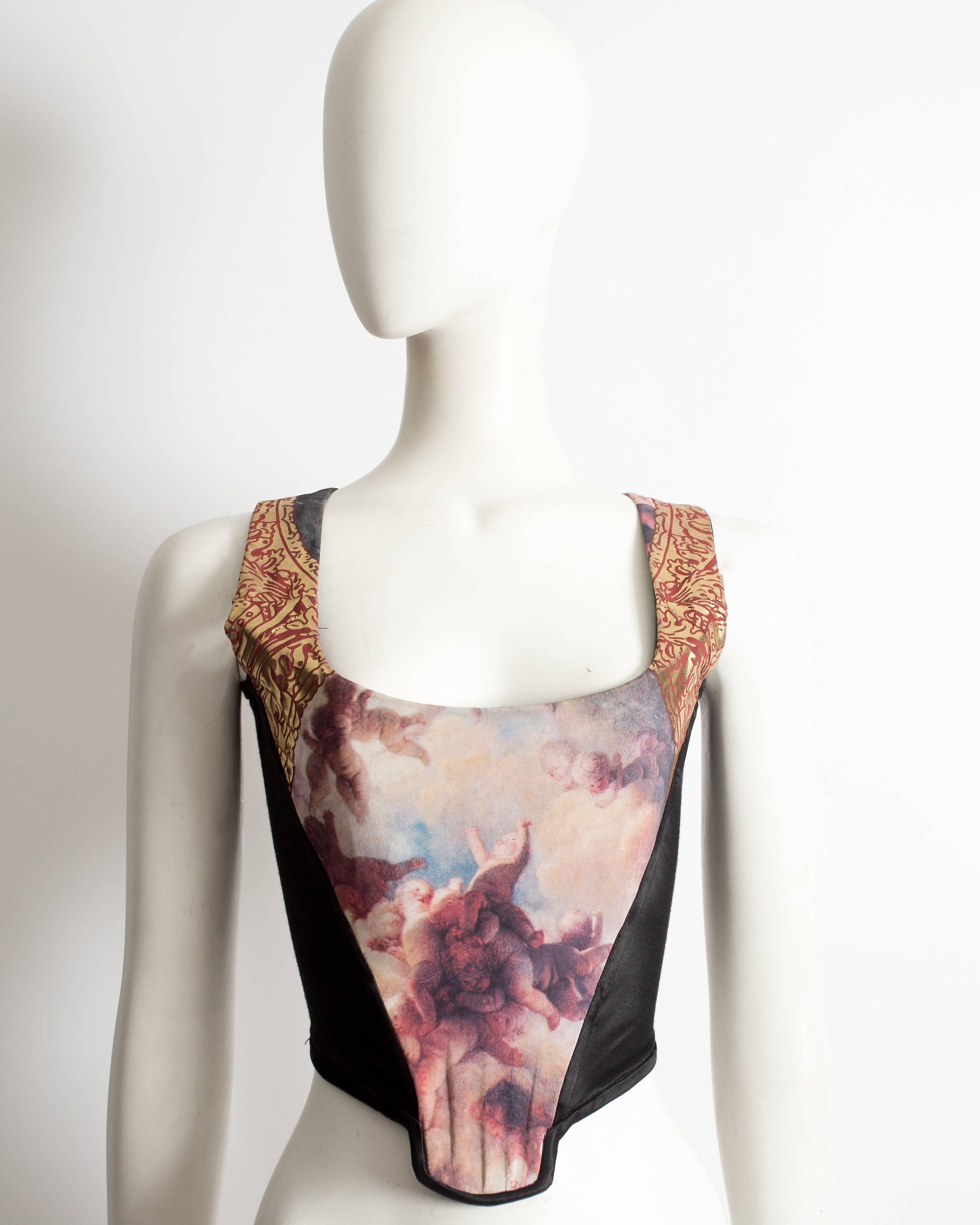 Rare and important Vivienne Westwood Cherub corset, Autumn-Winter 1991. Black satin panels, metallic gold baroque print on shoulder straps, zip fastening at the back and internal bonding on the front bodice. 

