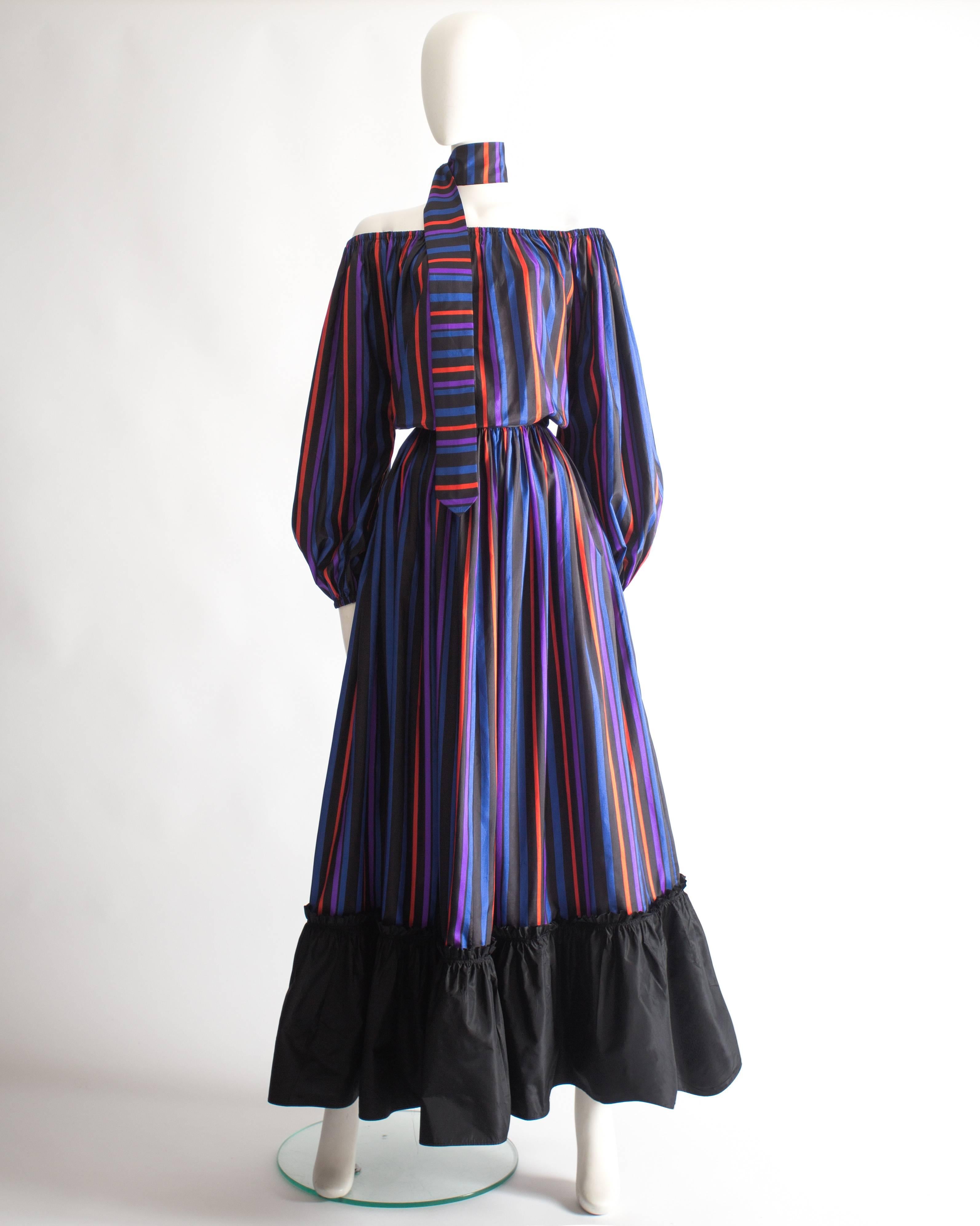 Lanvin Haute Couture evening dress, circa 1976. Striped pattern in blue, purple, red and black, elasticated cuffs and collar, off-the-shoulder design, two open pockets on the side seams, matching scarf and zip closure at the back. 

