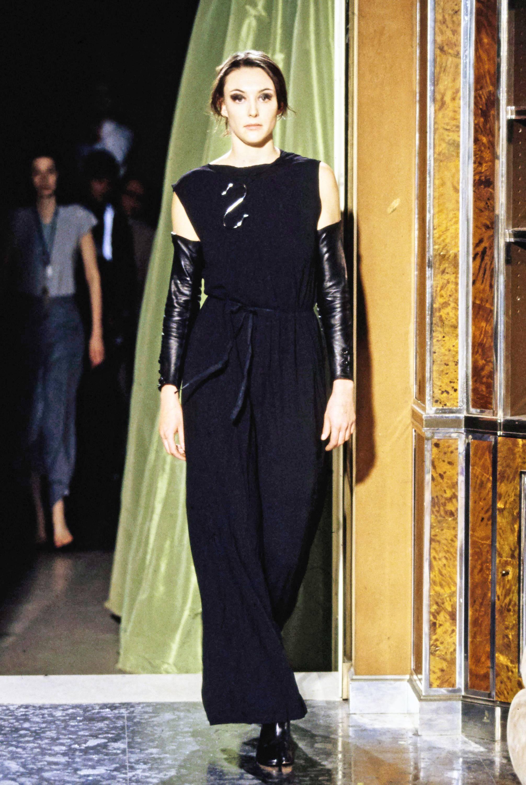 Introducing an archival Martin Margiela evening wrap dress, a masterpiece from the Spring-Summer 1999 collection that embodies the brand's timeless elegance and innovative design. This dress, crafted from black silk chiffon, promises to elevate your