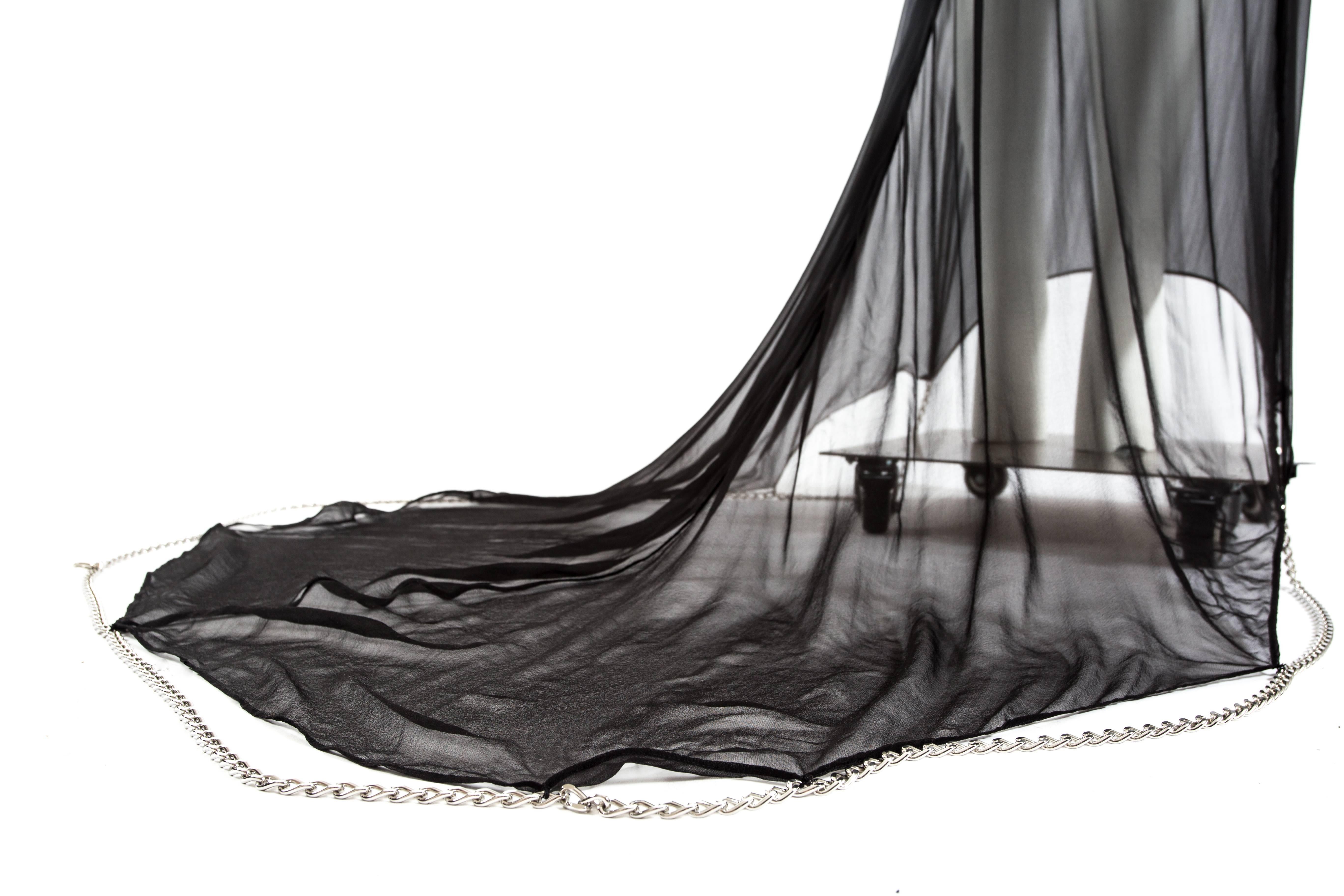 Maison Martin Margiela Spring-Summer 2010 black chiffon evening gown with chains

- deconstructed lapels on front and back
- train with attached silver metal chain
- the chain on the hem can attach to a hook on the side seam to lift the train from