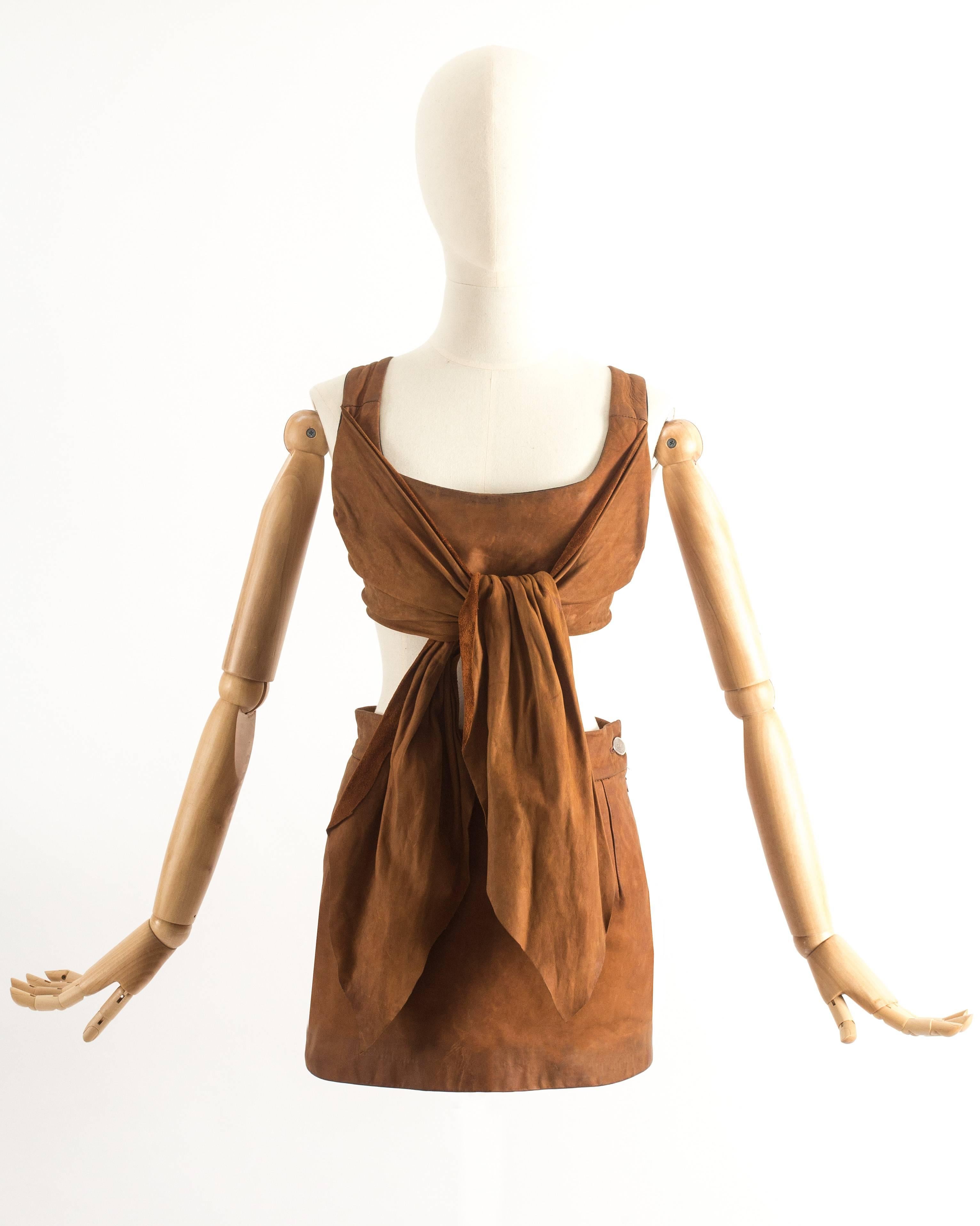 Vivienne Westwood Spring-Summer 1992 brown leather corset with boning, zip fastening and two long tie-up sashes at the front. High waisted mini skirt with slit at the rear.