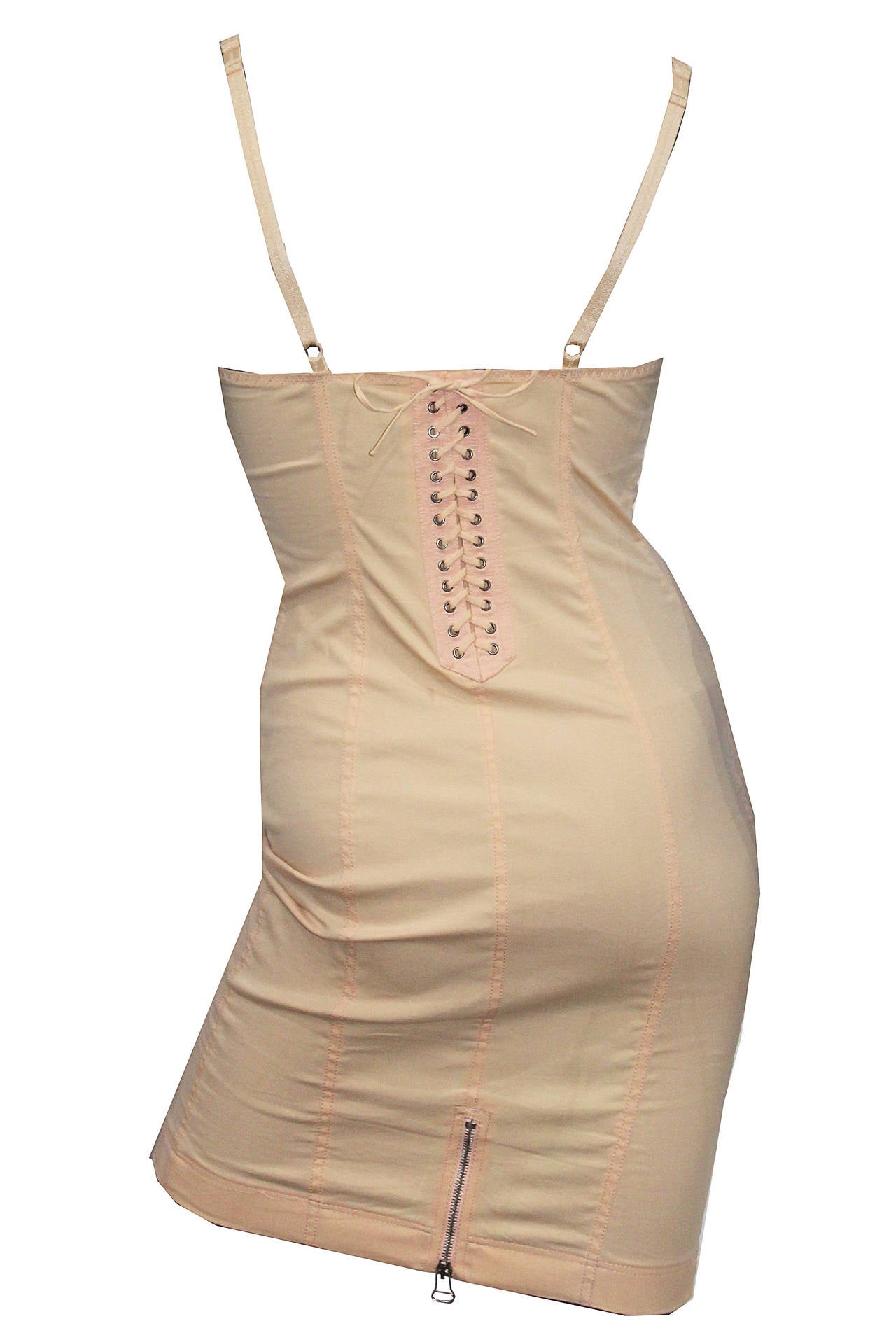 Iconic cone-bra bodycon dress from 1989. The dress is in a nude/peach colour and similar to skin tone. The bra straps are adjustable and features inside pockets to insert pads for the ultimate Gaultier/Madonna look. Lace up back with metal zippers.