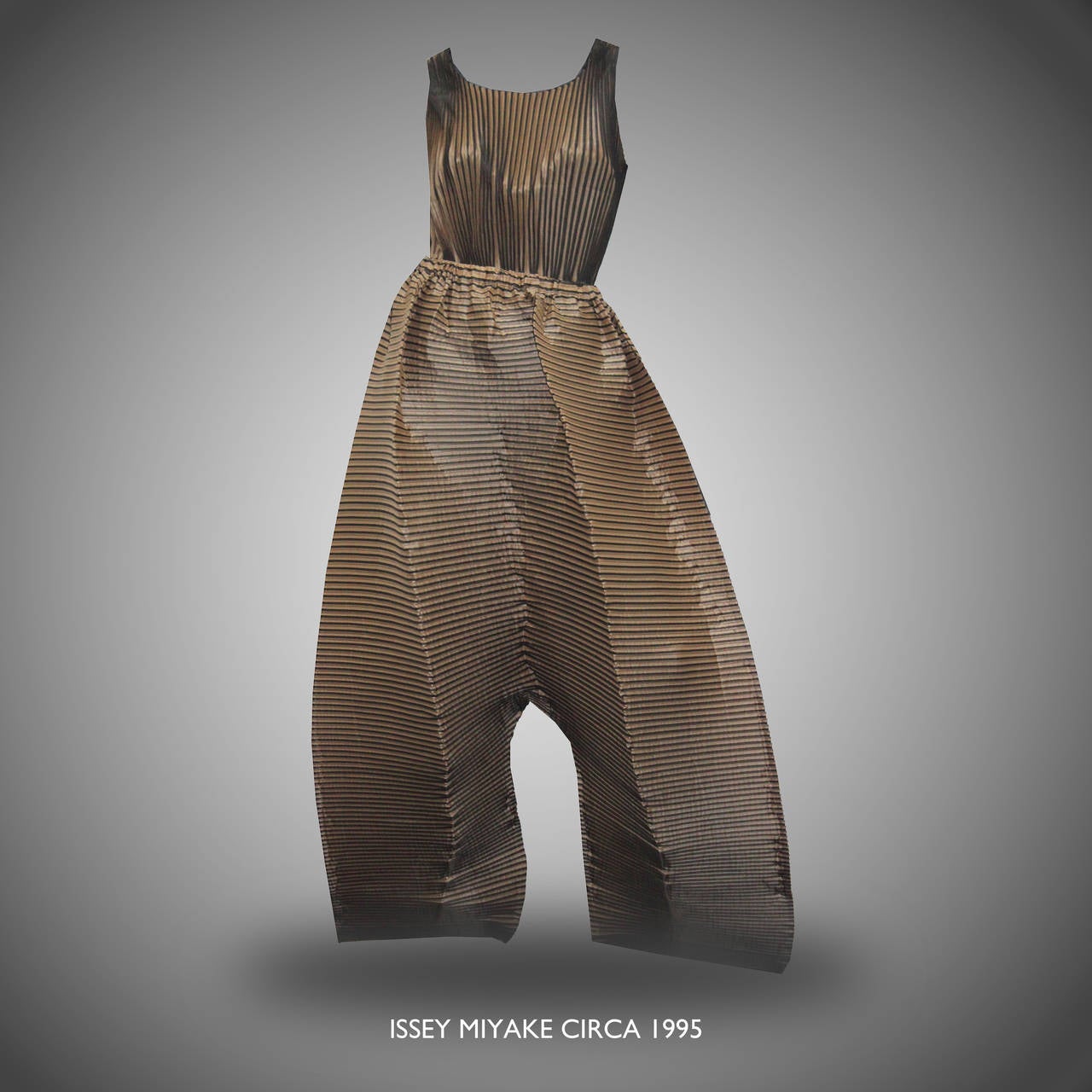 A rare Issey Miyake trouser suit, circa 1995. The suit features a pleated vest and super wide 3-D pleated trousers. The two contrasting colours are olive green and beige. 

Size Small

The trousers have an elasticated waist band and can either