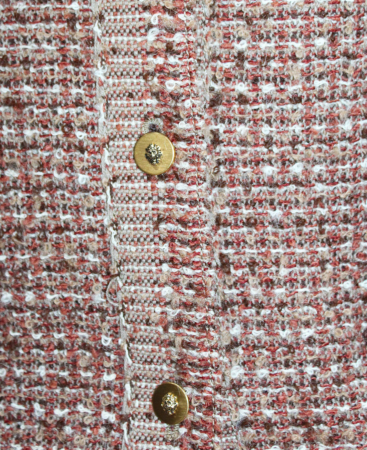 An iconic Chanel suit from the 1970s. 

Ensemble includes

- Chanel tweed jacket, lined in silk, chain hem, two front open pocket and gold lion buttons

- Chanel checked high neck silk shirt, back zip fastening 

- Chanel tweed skirt, two