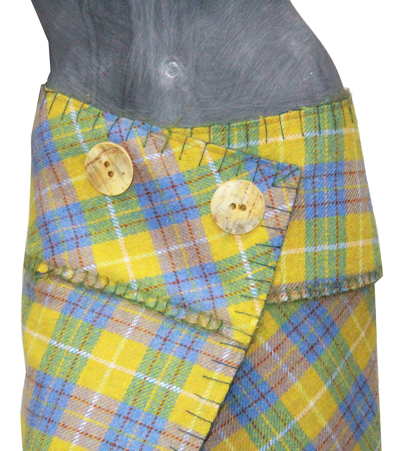 A Circa 1990s John Galliano plaid wrap skirt made from 100% wool, features to large shell buttons. 

styled with an Alexander McQueen plaid fringed jacket, also available at One of a Kind Archive. 

Fr 40 (However fits a size 36-38 nicely on the
