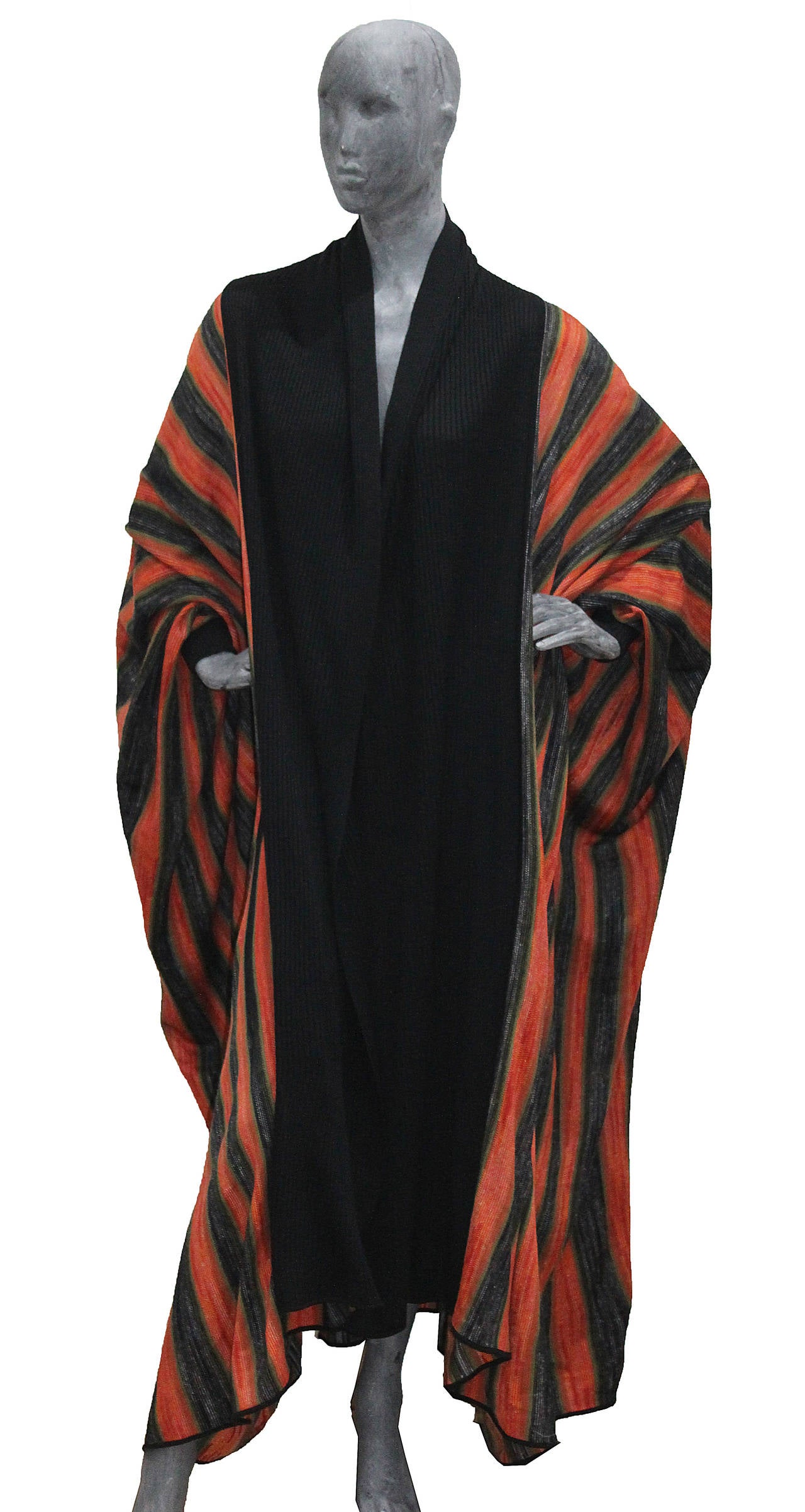 A rare 1970s striped knit cloak by Issey Miyake. The robe features huge batwing sleeves and a rib knit collar and cuff. Reference image found in the official Issey Miyake book. 

Size Medium