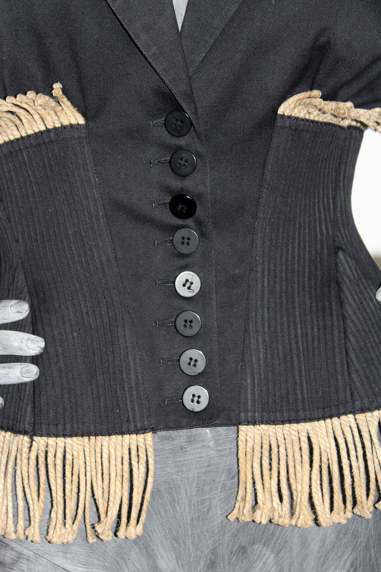 A 1980s Alaia corseted cotton jacket features 8 button opening through centre, 1 welt pocket and rope fringing. 

100% Cotton

Size: fr 40
Shoulder to shoulder - 18