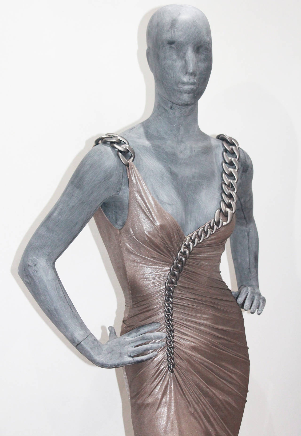 A beautiful Versace chain dress from the Autumn/Winter 2007. The dress is in a taupe metallic colour and is held up by a chain which wraps around the body. The exact dress in a different colour was worn by actress Jessica Alba for Fashion Rocks