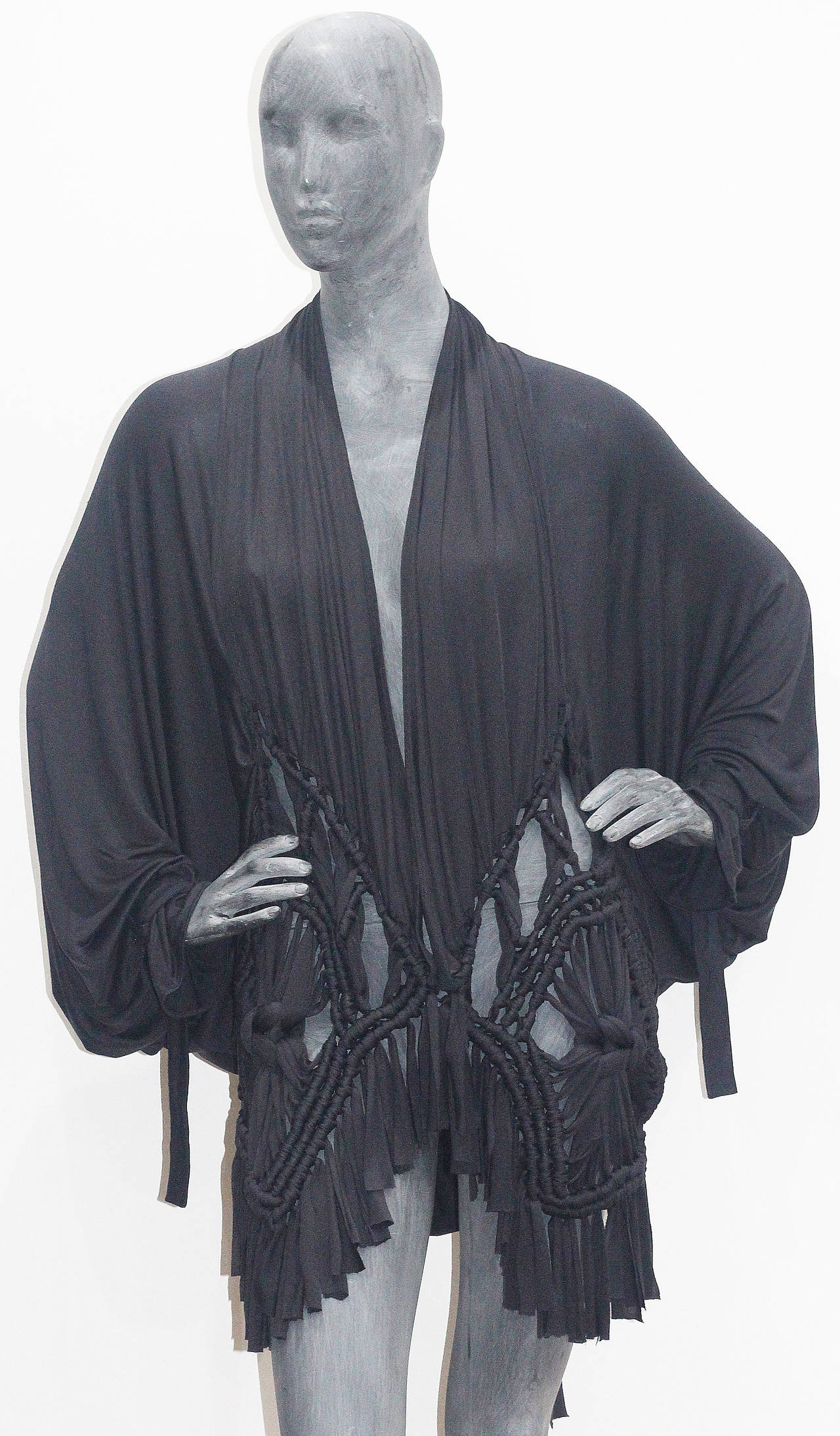 A Christian Dior Macramé batwing cardigan made from 100% silk jersey. The cardigan features belted cuffs, macramé technique and hook closure. This cardigan was made for the Spring/Summer Christian Dior runway show in Paris and was designed by John